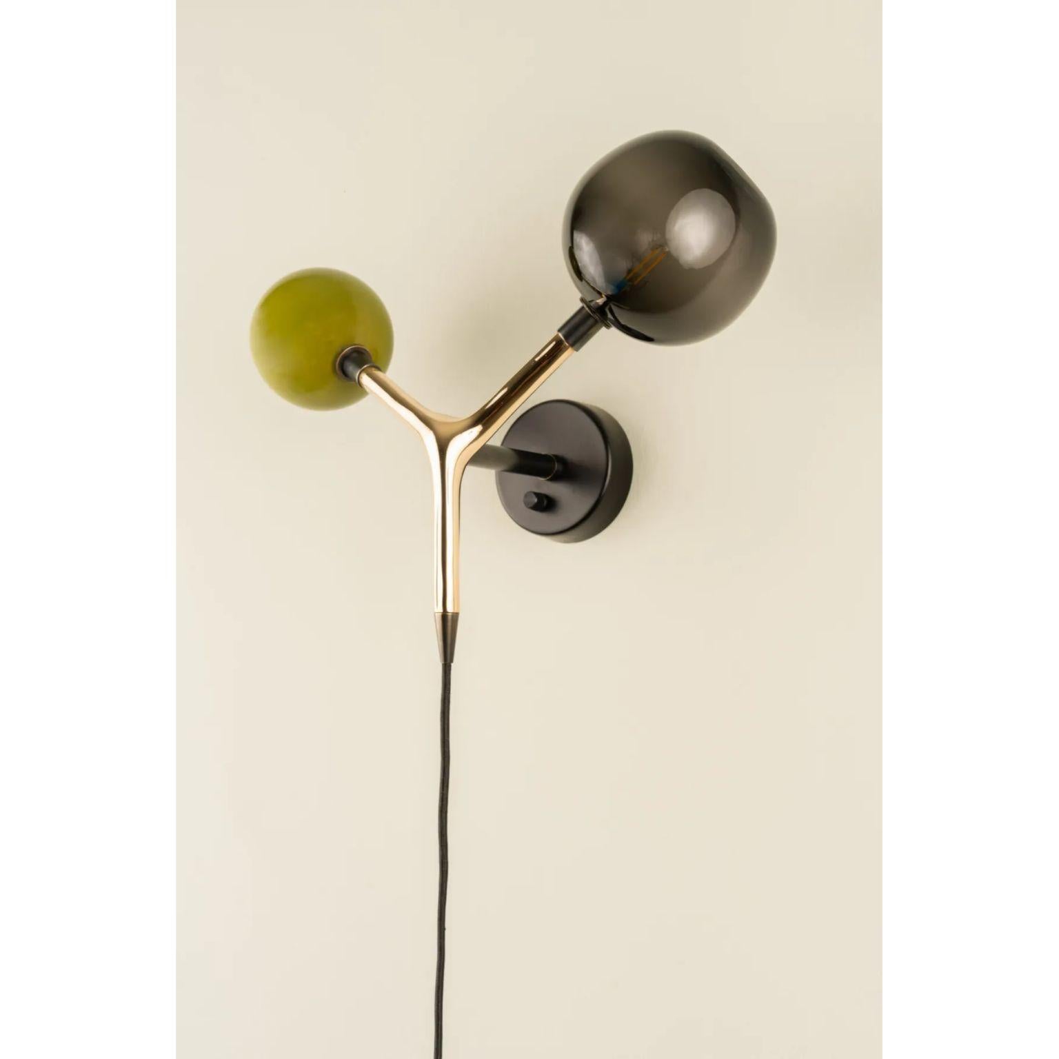 Ojos Olive and Smoke Sconce by Isabel Moncada
Dimensions: D 24 x W 49 x H 35 cm.
Materials: Cast bronze body, two blown glass globes, brass fittings and rayon sheathed cable.

Eyes that glow to be seen.
This sconce is the perfect solution for any