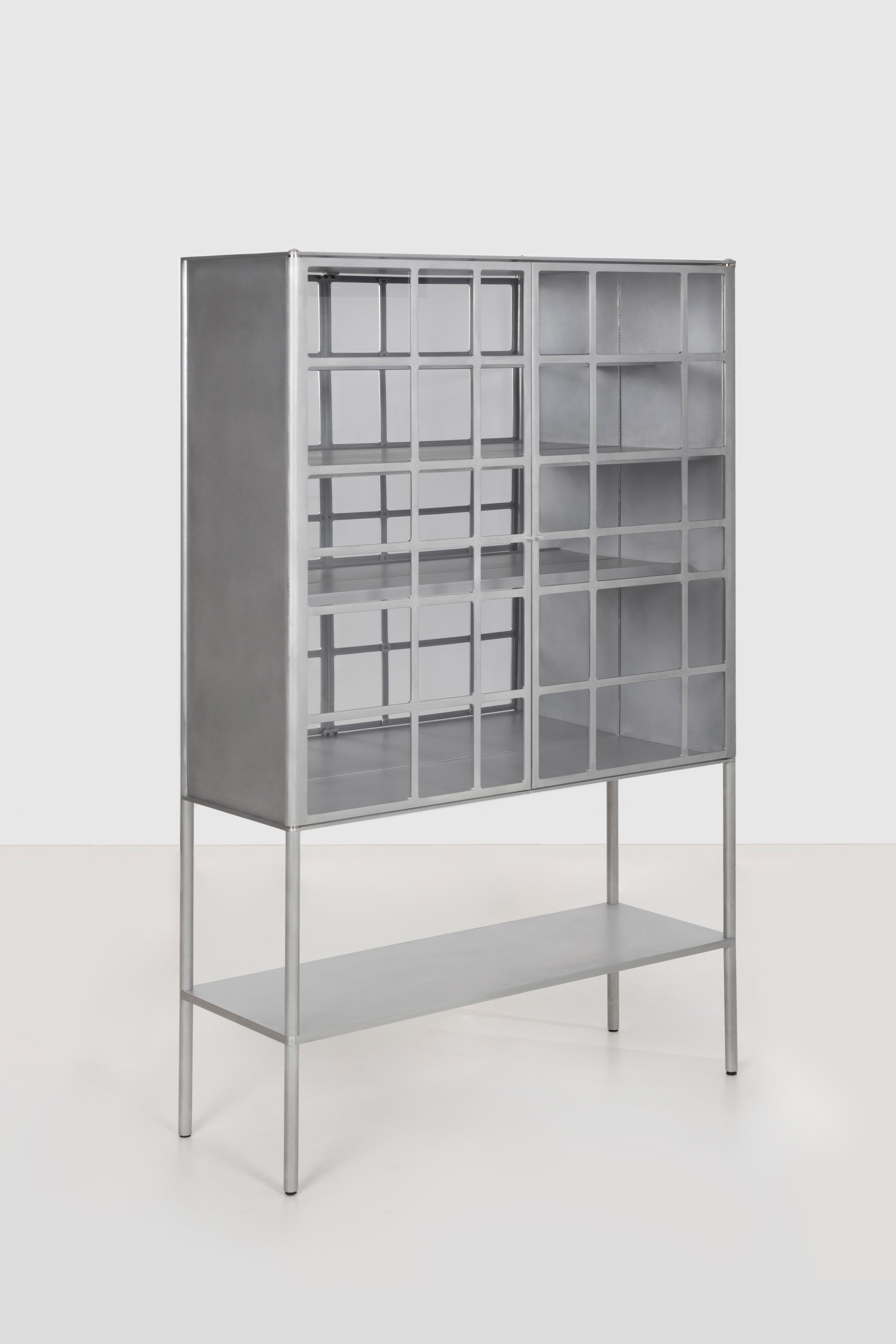 OK whiskey cabinet, in cut, milled, and machined aluminum. Milled acrylic window inserts are set from the reverse and fastened with a custom washer. Inset foot levelers are concealed within the solid aluminum leg. The lower shelf is a solid