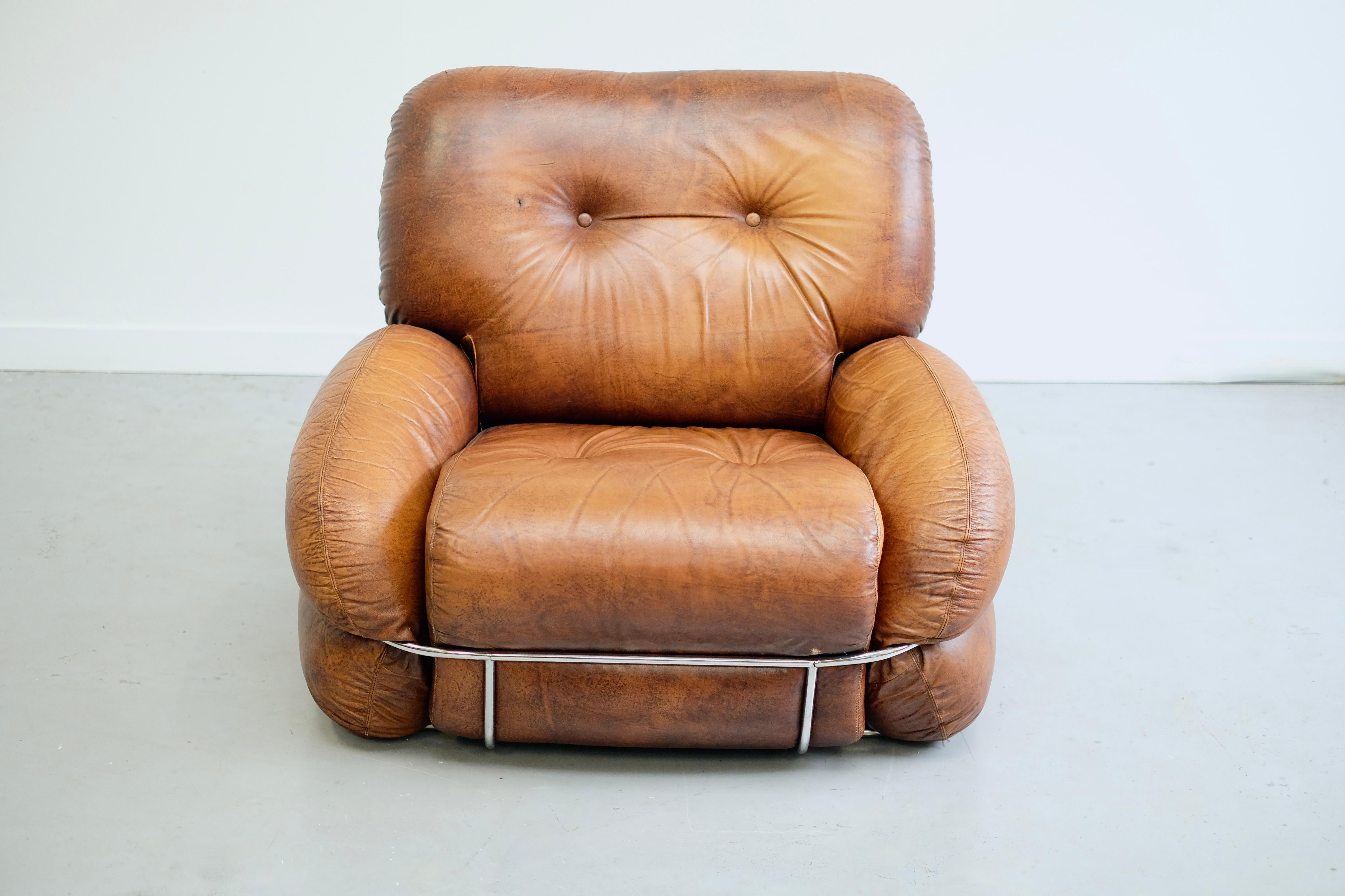 Mid-century leather lounge chair by Adriano Piazzesi in the 1970s.
It is made of generously proportioned tufted cognac leather, with curved chrome supports on the sides, front and back.
It is extremely comfortable, chic and would look great in an