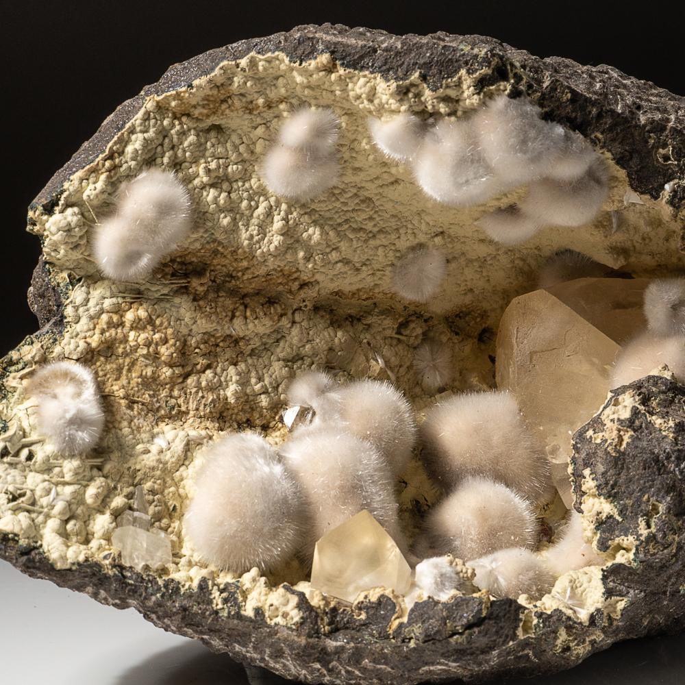 From Bombay Quarry, Mumbai (Bombay), Maharastra, India Hemispherical cluster of hair-thin okenite crystals in a geode lined with calcite along side large calcite crystals with rhombic faces. The naturally-occurring combination of okenite and calcite