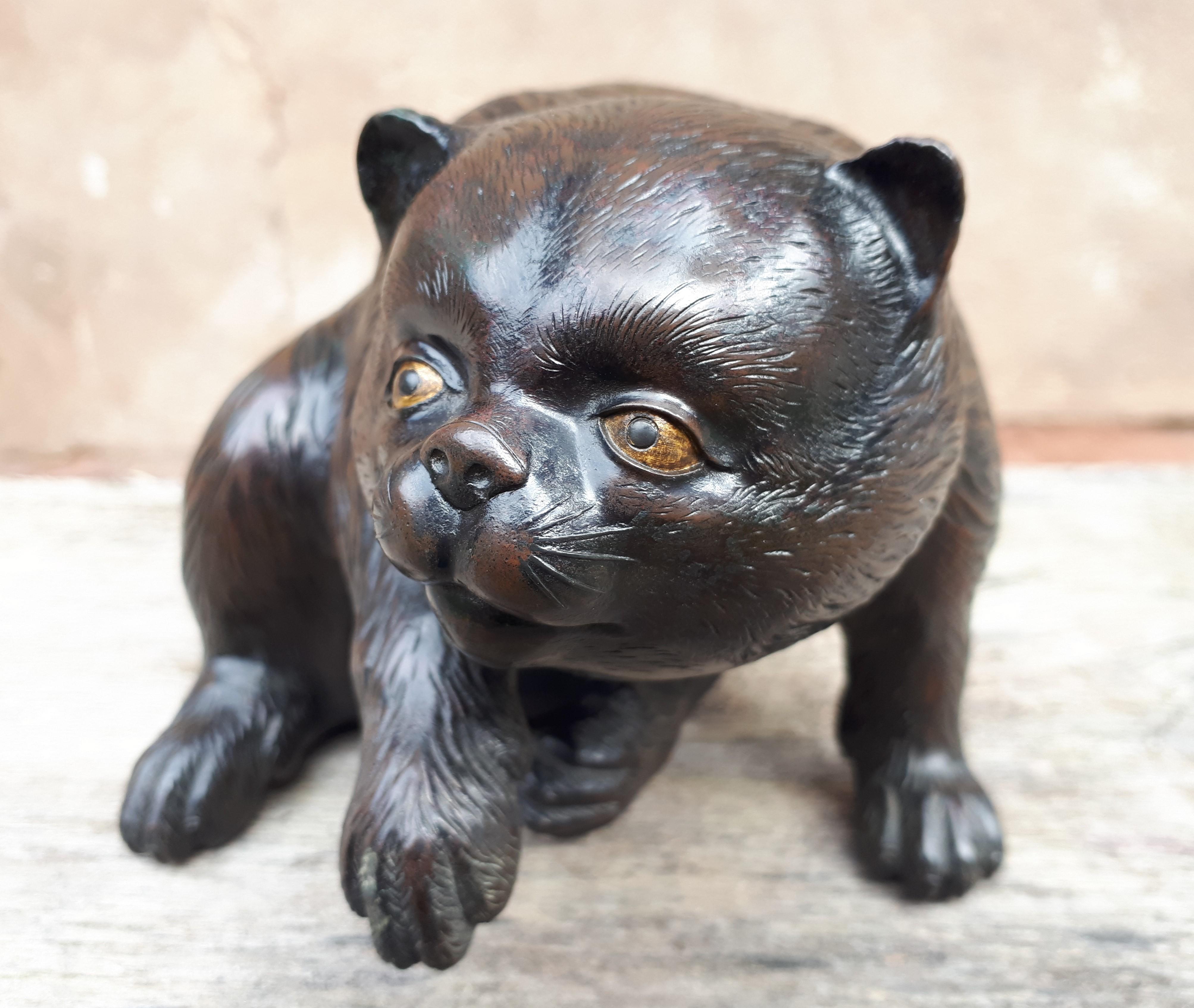 Charming bronze okimono depicting a sitting puppy raising its paw and looking into the distance.
High quality, highly detailed sculpture, the eyes inlaid with gold and shakudo.
Signed 