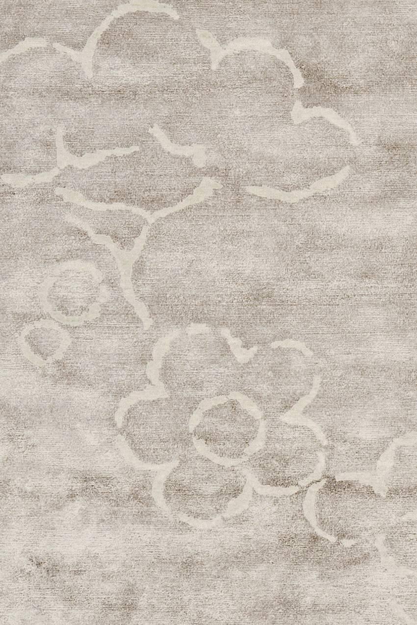 Okoa rug is made in blended wool and silk (70-30%). 
Low pile (5-6 mm). 
Quality: 100 knots by square inch. 
Base light warm grey, pattern natural white.
Hand-knotted in Nepal.
 