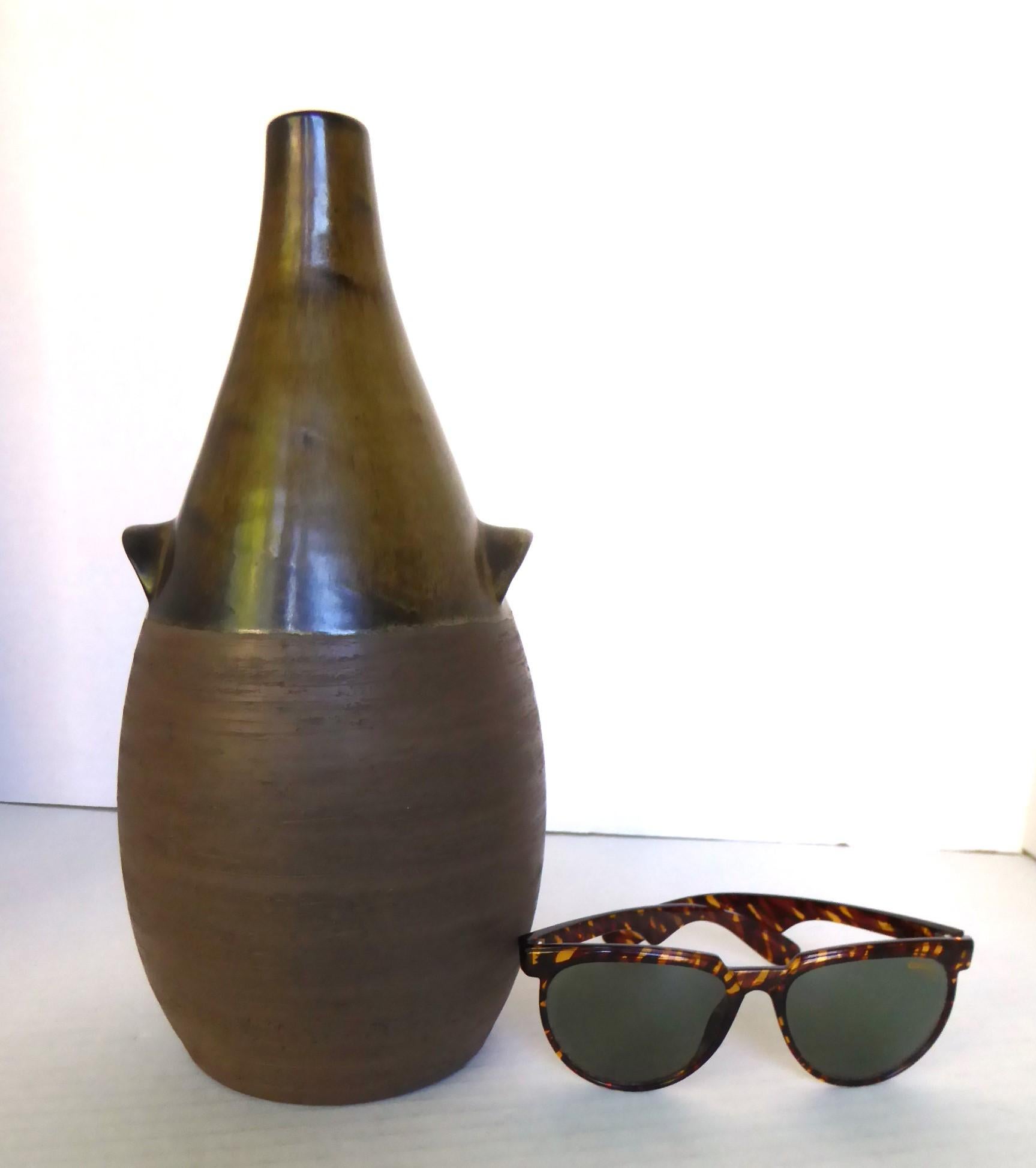 Danish Mid Century Modern wholesaler of ceramics BR (Brothers Rasmussen) had this beautiful Organic pottery vessel designed and created.  This piece has a jug form and has a textured unglazed bottom half while the neck is finished in a spotted olive