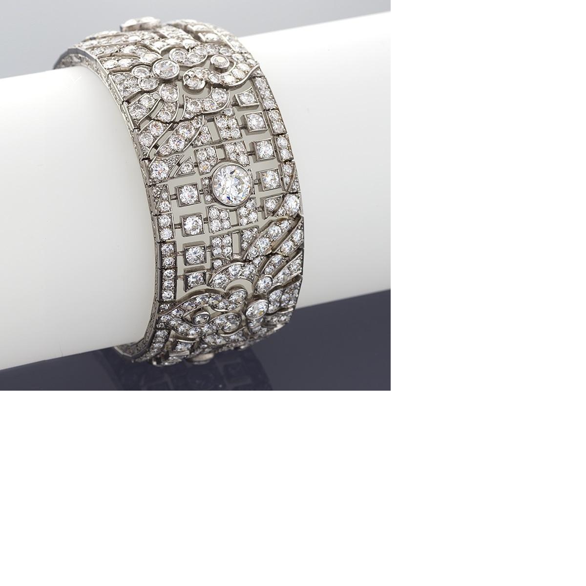 Created by Okrant et Davidonniez, Paris, this broad and beautifully-articulated Art Deco wide strap platinum bracelet, with its stylized motifs, is delicately set with over forty carats of sparkling old European-cut diamonds. With its exquisite