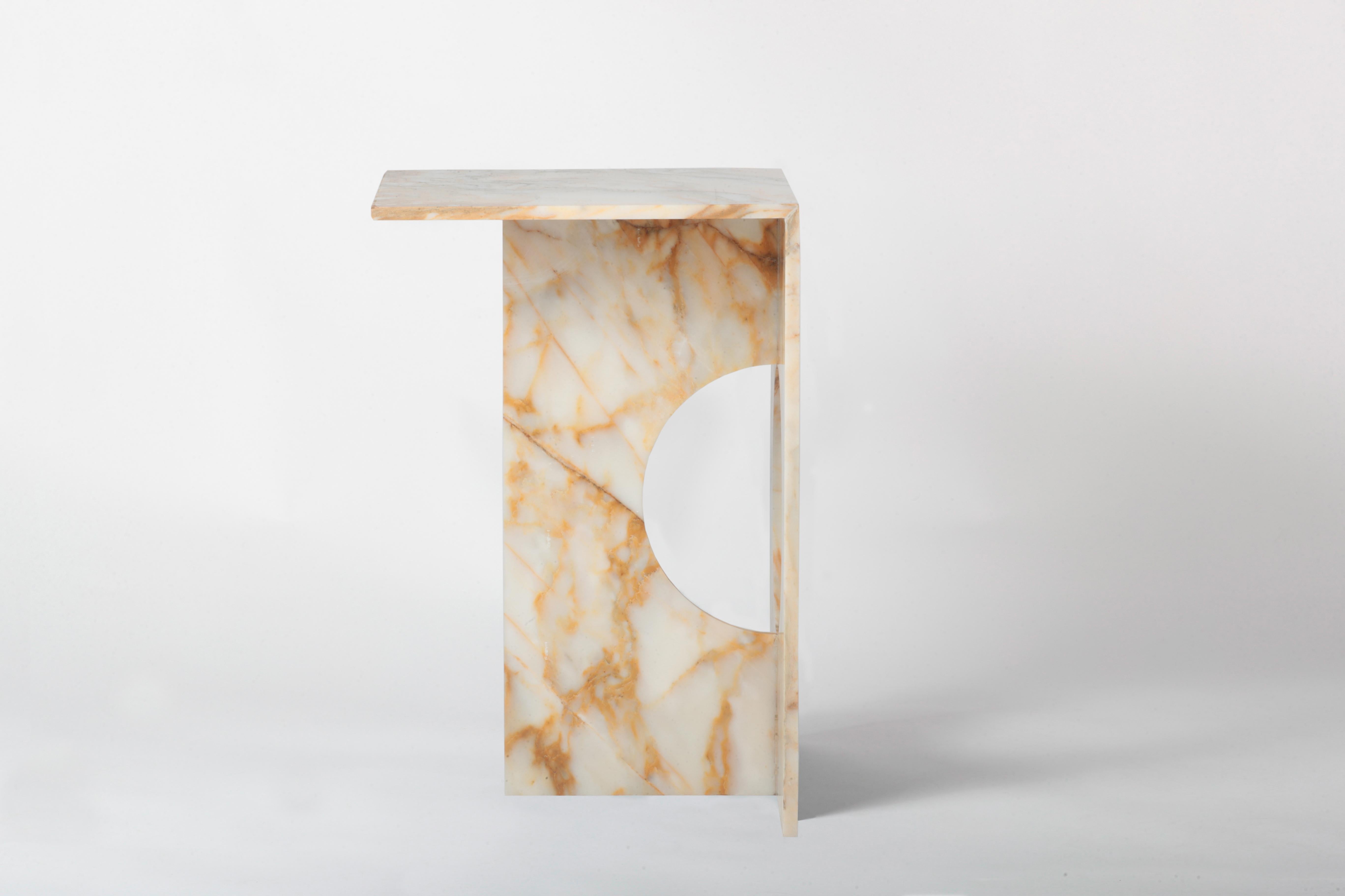 Une table d'appoint entièrement réalisée en marbre fait de cette pièce une sculpture moderne. La table d'appoint Ola peut être réalisée en différents marbres ou en pierre de diabase verte si nécessaire. La perfection de la coupe à la machine se mêle