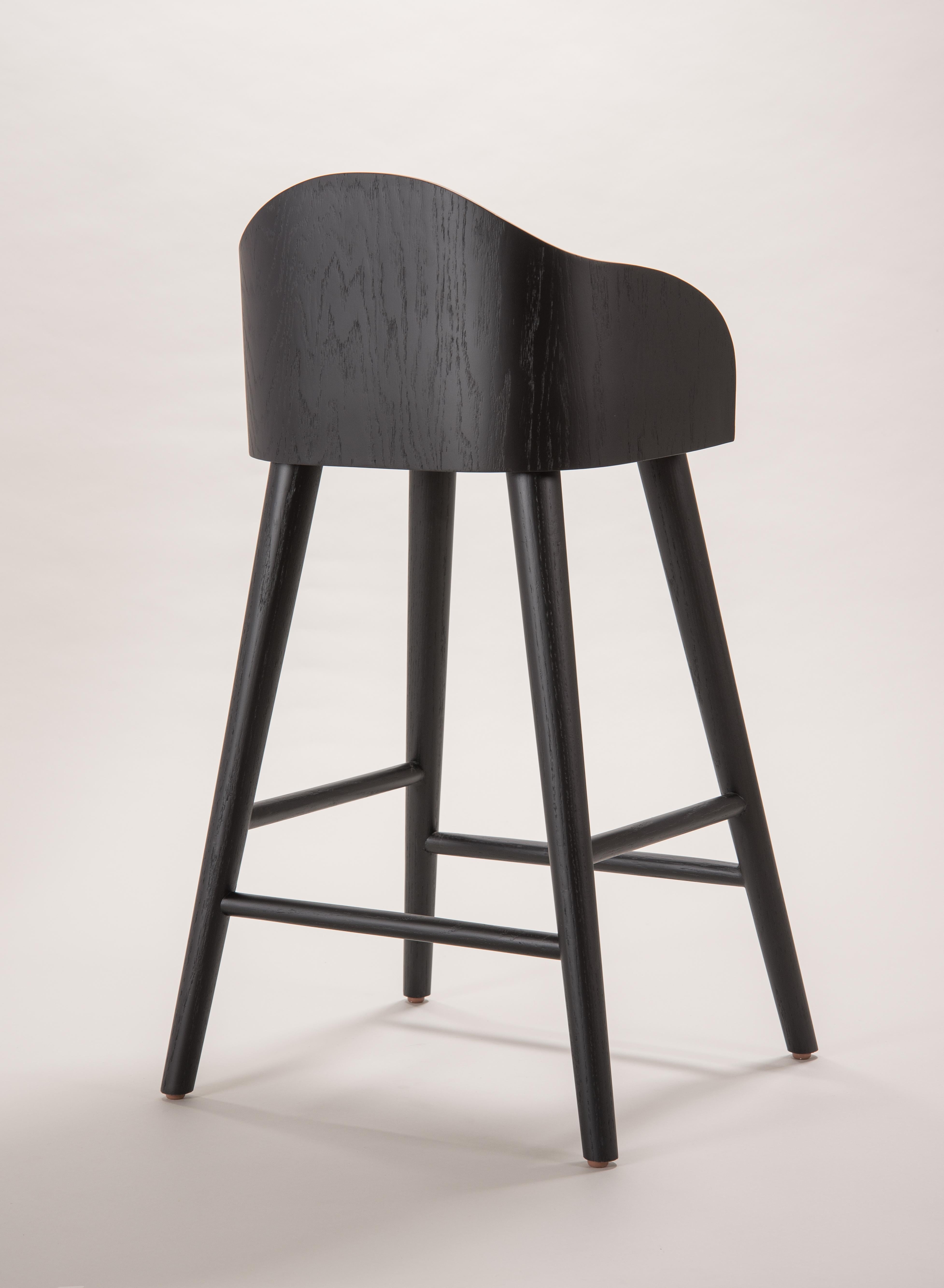 The peaceful movement of a wave flows by the stylized lines of the stools, refreshing in its organic design made with oak inked in black. Qualities such as definition, symmetry and proportion, allows the Ola stools to be a pleasant contrast to
