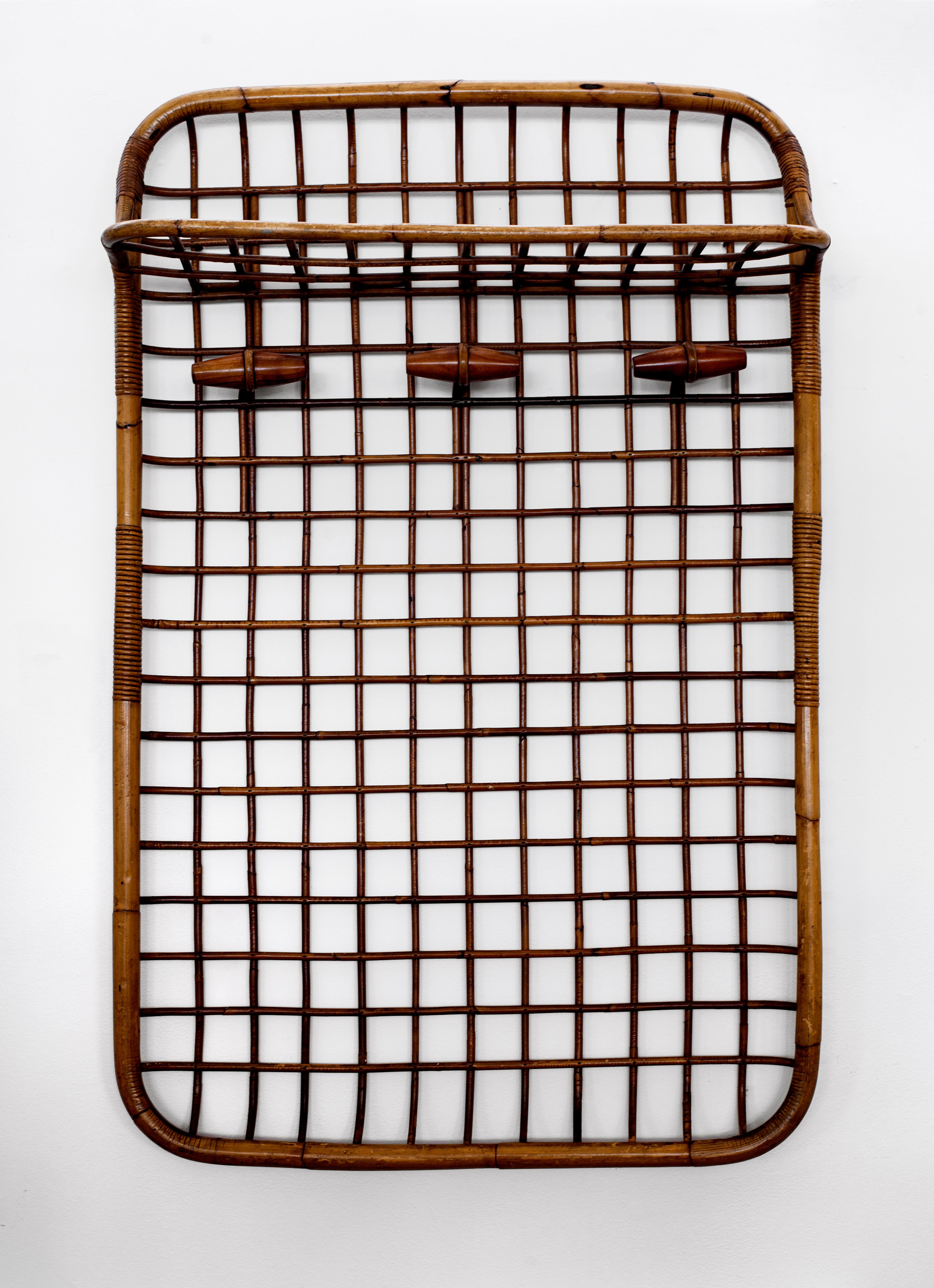 Great rattan wall coat rack by Olaf von Bohr for Bonacina. Rattan and bamboo grid design with upper shelf and 3 wood hooks. Nice patina throughout. Beautiful entry-way or bedroom piece.