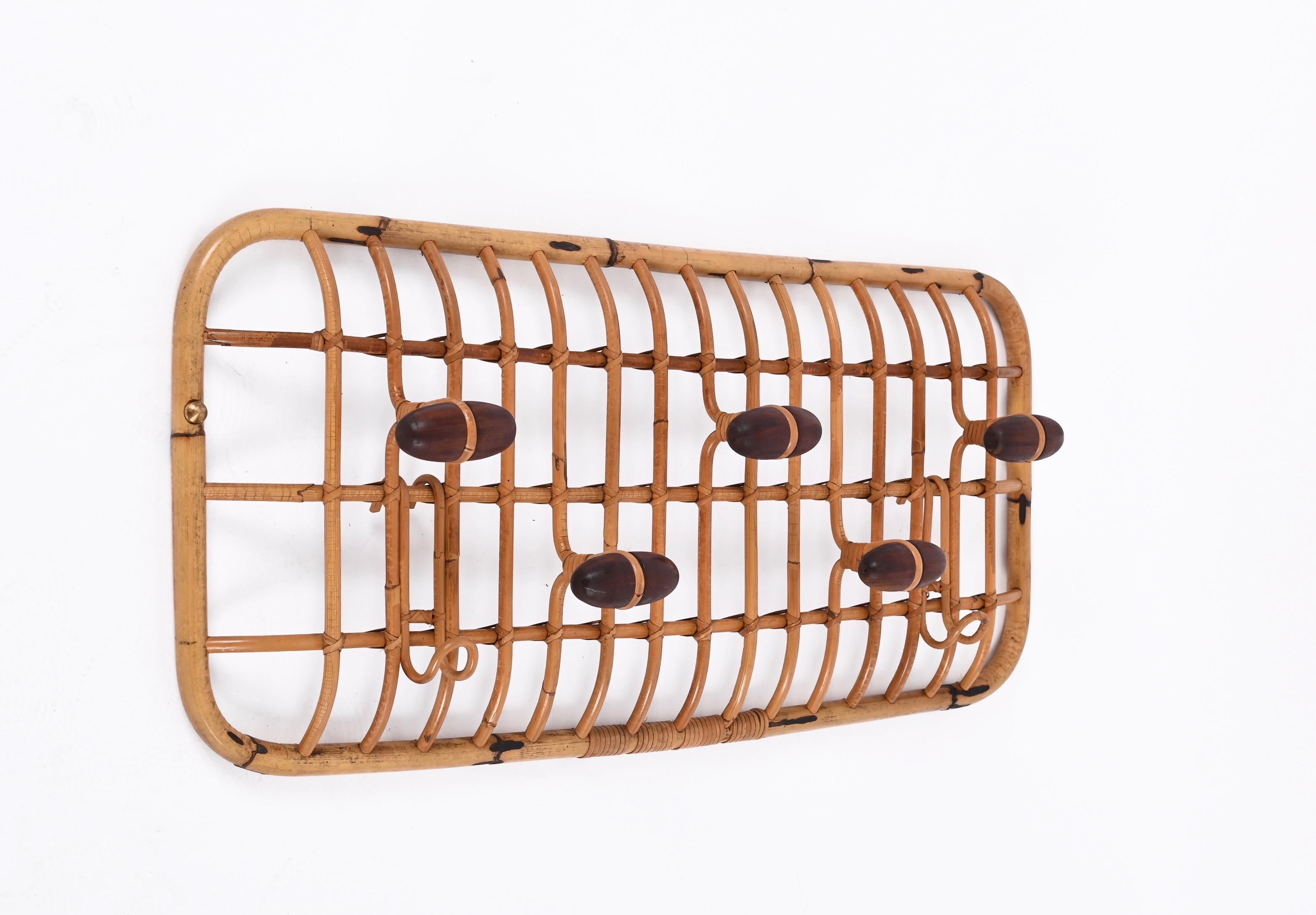 Gorgeous midcentury coat rack in bamboo, rattan and walnut wood by Olaf von Bohr for Bonacina, produced in the 1960s in Italy.

This iconic piece features a bamboo and rattan structure with five hangers in dark walnut wood and two curved bamboo