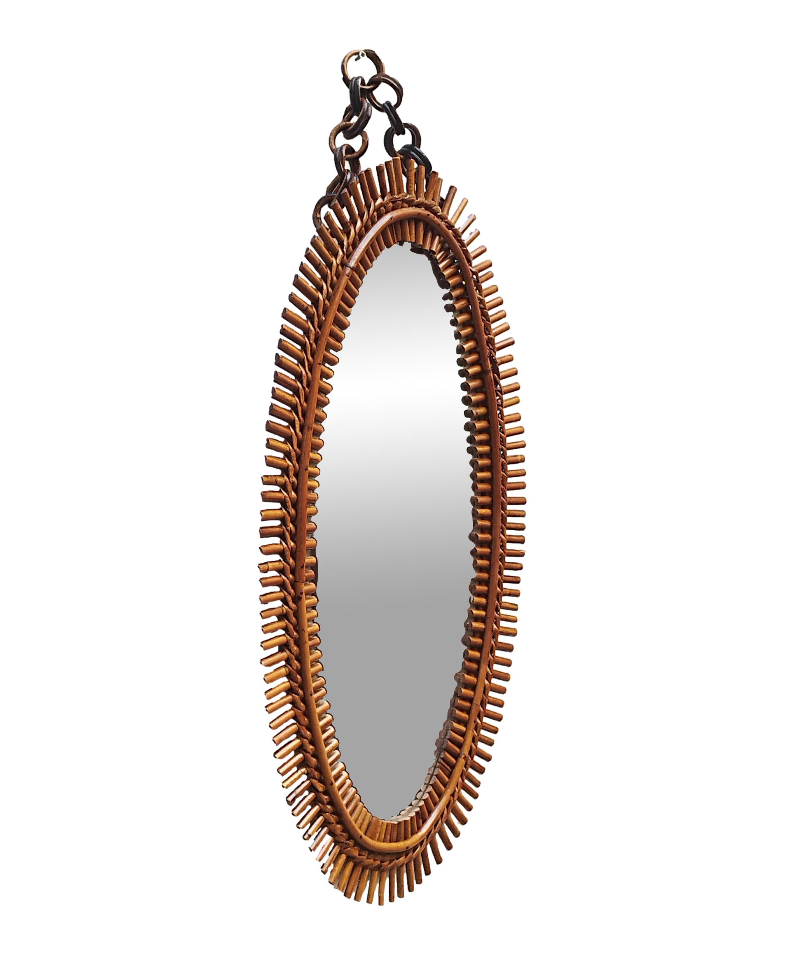  Oval bamboo wall mirror, consisting of an oval glass surrounded by an ingenious frame formed by two bamboo roundels joined by a dense weave of prickly pear prickly pear small rods arranged radially around the fulcrum of the oval mirror. Designed by