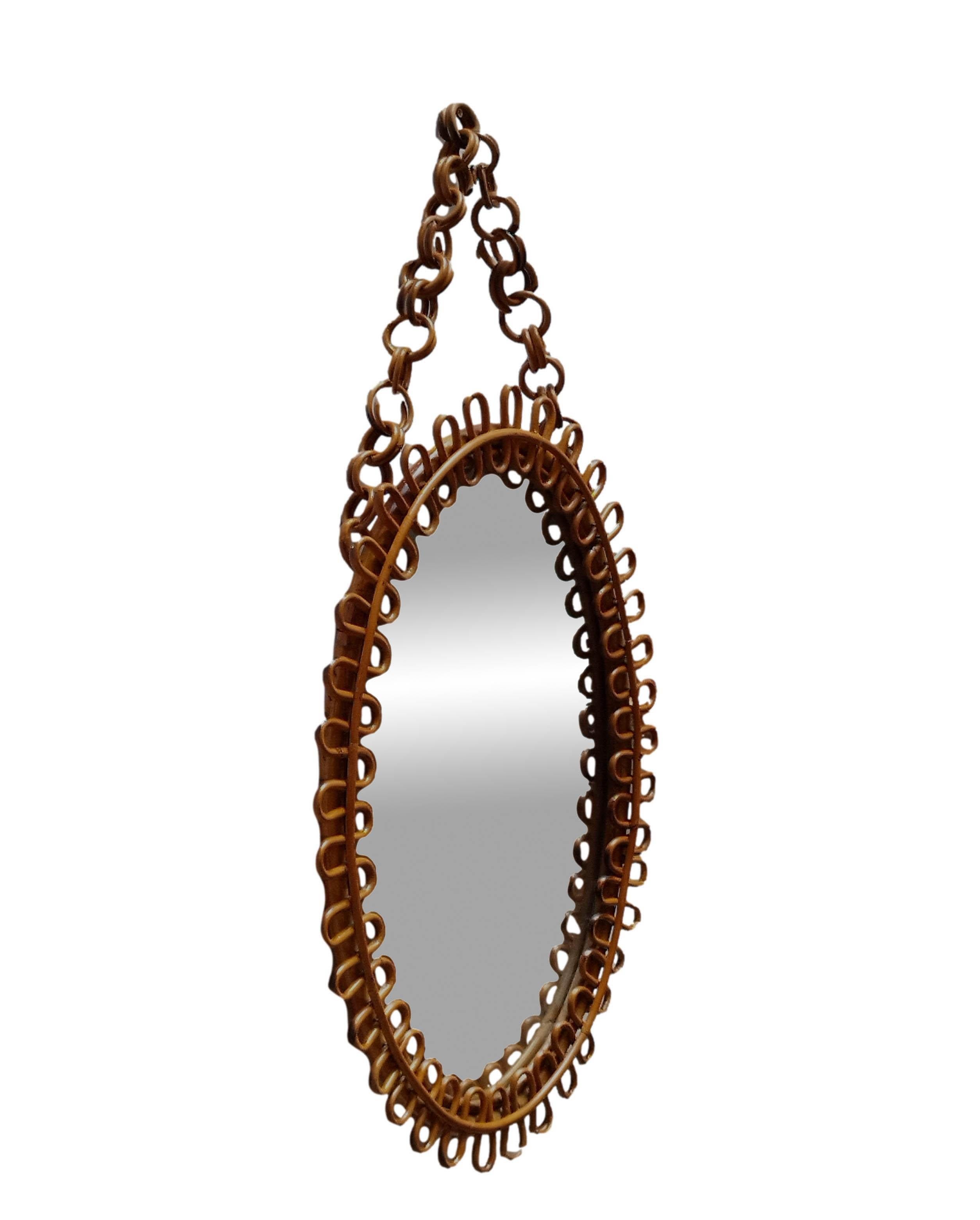 The mirror consists of an oval glass surrounded by an ingenious frame formed by two turns of bamboo joined by a dense weave of prickly pear cane to rods arranged radially with respect to the fulcrum of the oval mirror.
Oval mirror made of bamboo