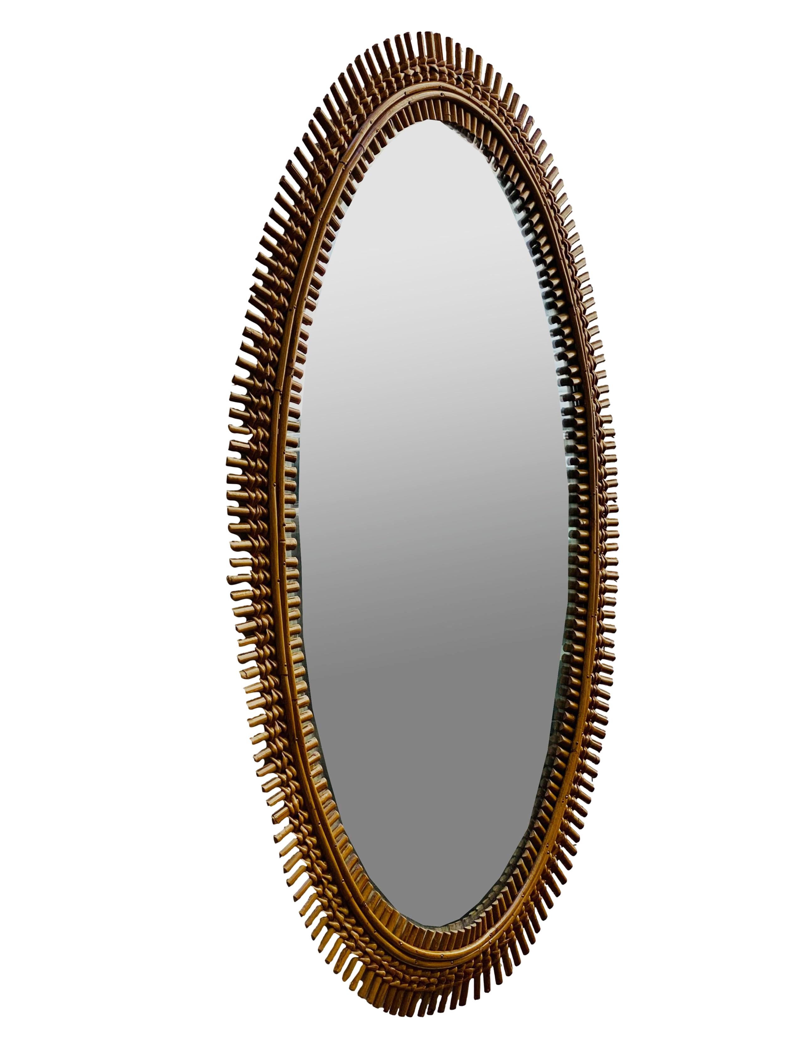 Large oval bamboo wall mirror, designed by renowned designer Olaf von Bohr for the Bonacina company. It is definitely interesting because of its slender oval shape and its eye-catching sunburst construction with balanced proportions, features