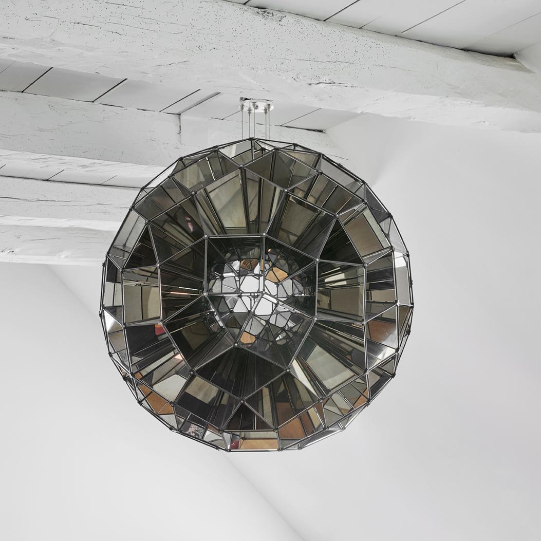 Dynamic Installation by Olafur Eliasson entitled “Square Sphere”. A stainless steel, mirror and bronzed brass construction, from an edition of 10 pieces executed in 2007. 

The mirrors create kaleidoscopic effects that mix fragmentary reflections