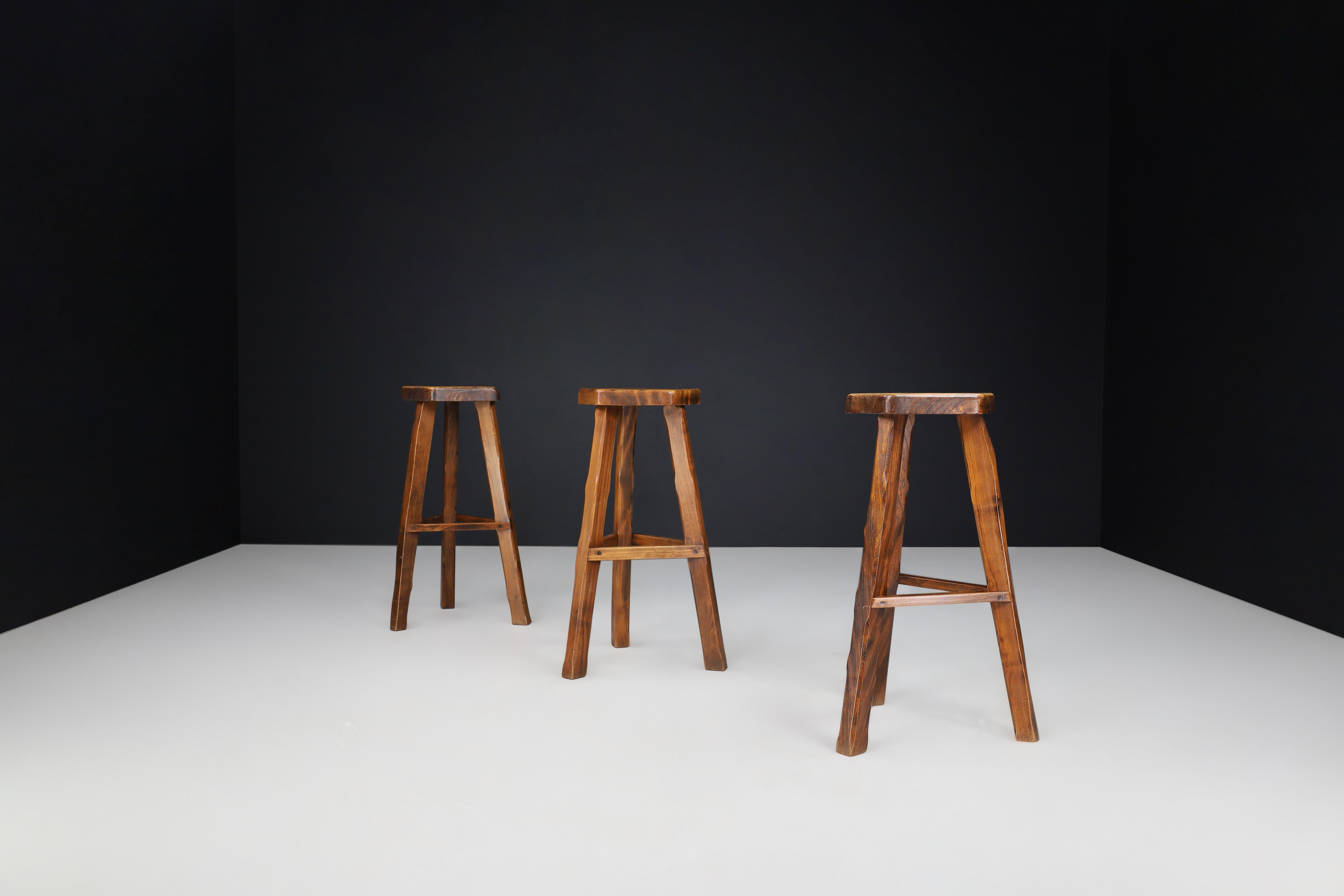 Olavi Hänninen Brutalist Elm Wood Bar Stools, Finland 1960s 

These set of 3 bar stools, crafted by Finnish designer Olavi Hänninen in the 1960s, boast unique warm tones due to their dark stained Elm wood construction. Hand-carved with precision,