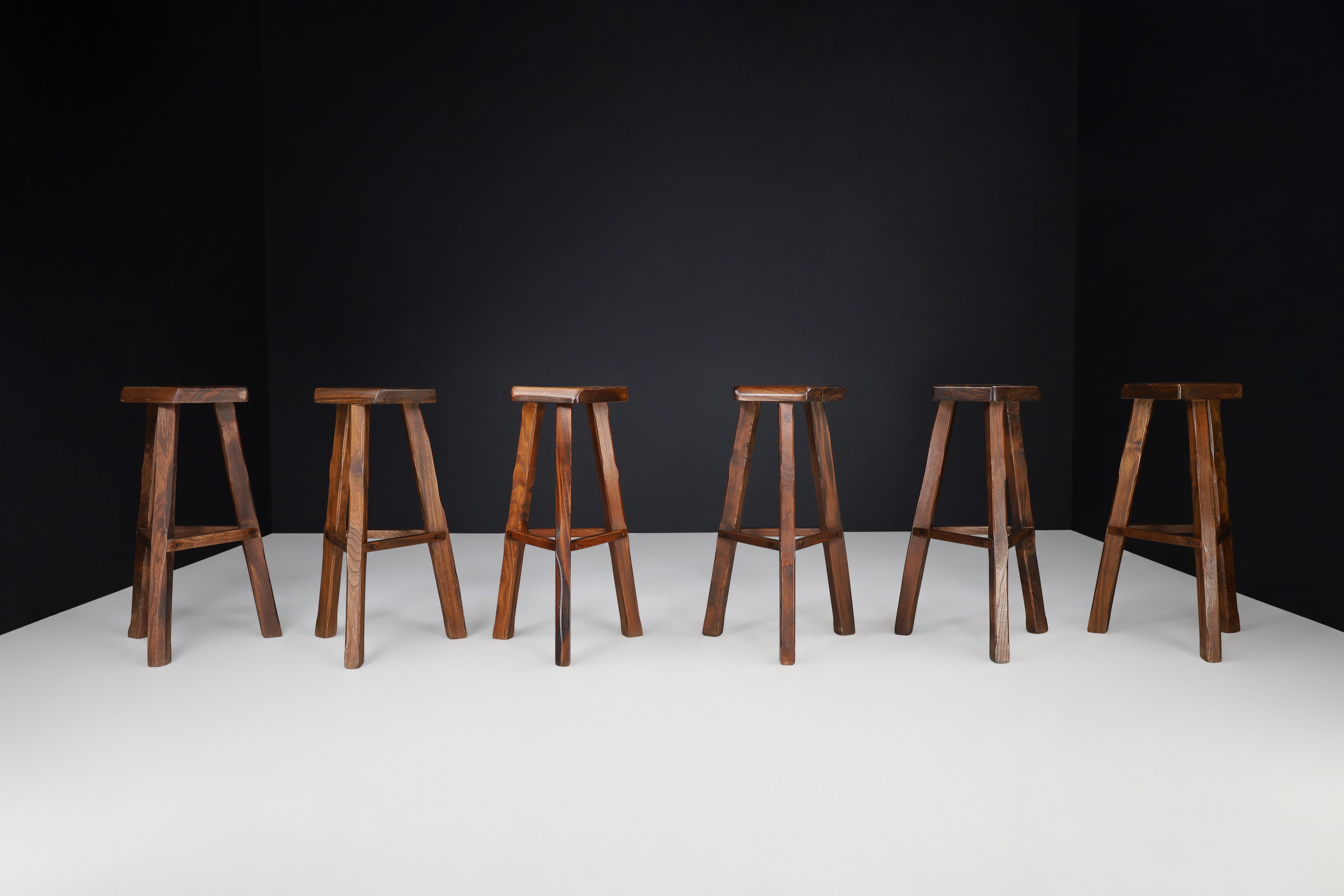 Olavi Hänninen Brutalist Elm Wood Bar Stools, Finland 1960s 

These set of 6 bar stools, crafted by Finnish designer Olavi Hänninen in the 1960s, boast unique warm tones due to their dark stained Elm wood construction. Hand-carved with precision,