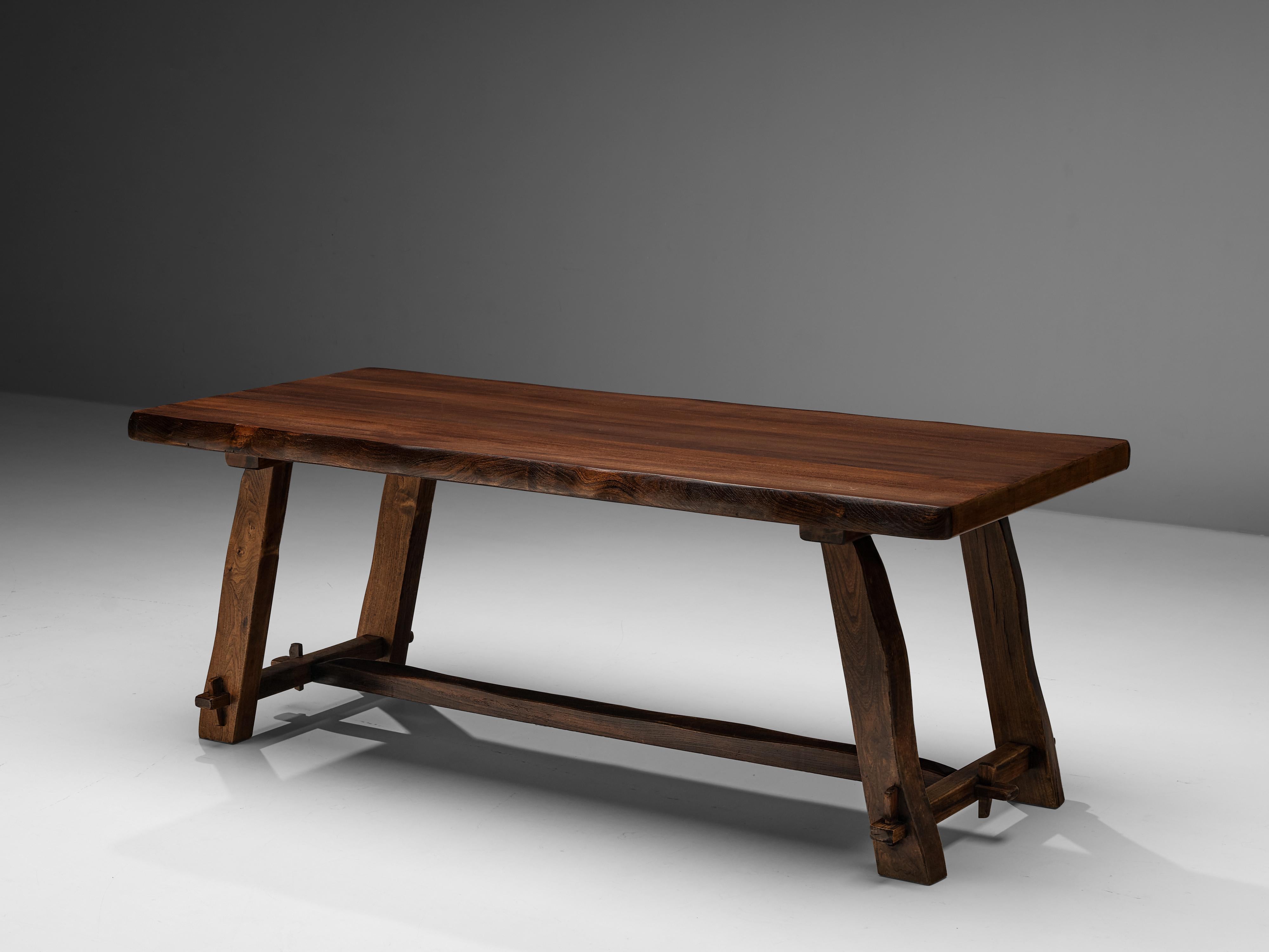 Olavi Hanninen for Mikko Nupponen, dining table, stained elm, Finland, 1950s 

This rustic dining table by Finish designer Olavi Hanninen features a wonderful composition of strong lines and organic edges. The thick tabletop rests on four sloping