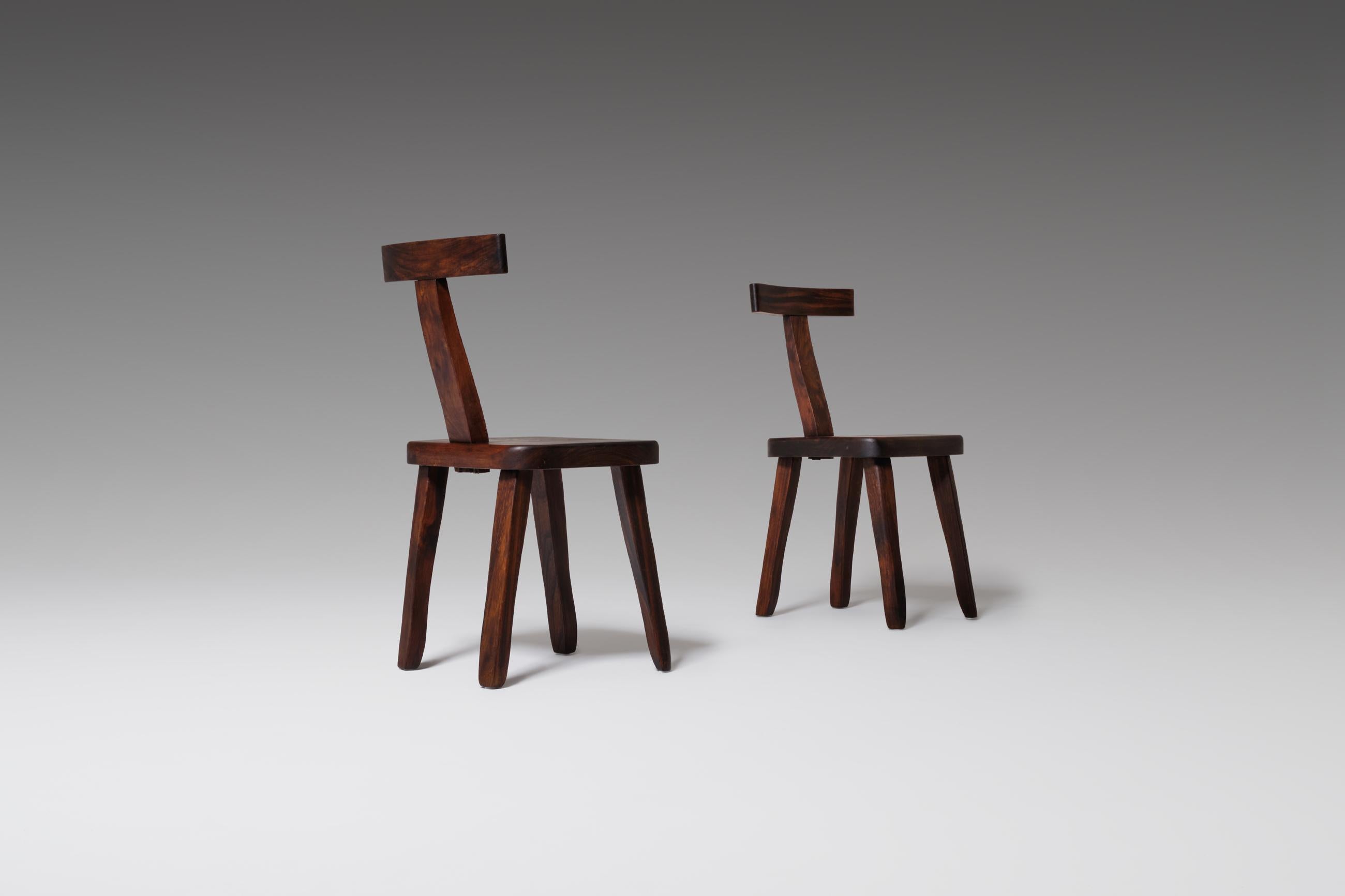 Set of two sculptural side chairs by Olavi Hänninen for Mikko Nupponen, Finland, 1950s. The chairs are constructed out of dark stained Elm wood with nice warm tones. Every single element of the chairs is carved by hand, therefore no piece is the