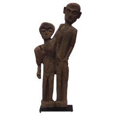 Old 4 foot high naive and stylized carving of two people from 1 slab of wood