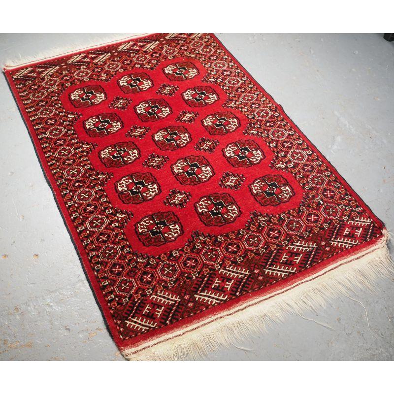 Old Afghan rug of traditional Tekke Turkmen design, the rug is a clear red colour.

The rug is of the classic Tekke Turkmen gul design with three rows of five Tekke guls. The rug has multiple borders and elem panels at each end. The rug retains