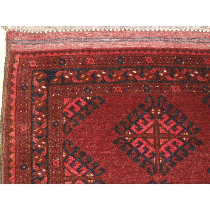 Old Afghan village rug of traditional Turkmen style design with large dyrnak guls.

The rug has a warm madder red colour with lighter highlights in the guls. Both ends have the original decorated kilim end finishes.

The rug is in excellent