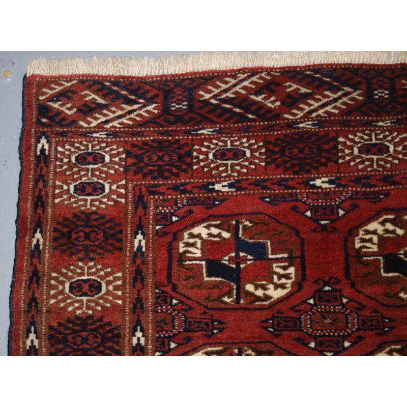 Old Afghan village rug of traditional Turkmen style design with Tekke guls.

The rug has a soft madder red colour even looking slightly faded in places with three rows of seven large Tekke guls. The border is the Turkmen sunburst design.

The