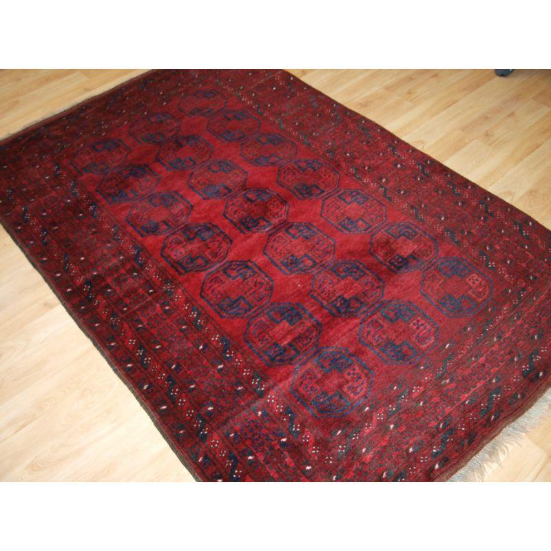 Alter afghanischer Dorfteppich mit traditionellem Design, der Teppich hat 3 Reihen mit 7 großen afghanischen Guls.

Der Teppich hat eine ausgezeichnete satte rote Farbe mit dunklem Indigoblau.

Der Teppich ist in ausgezeichnetem Zustand mit