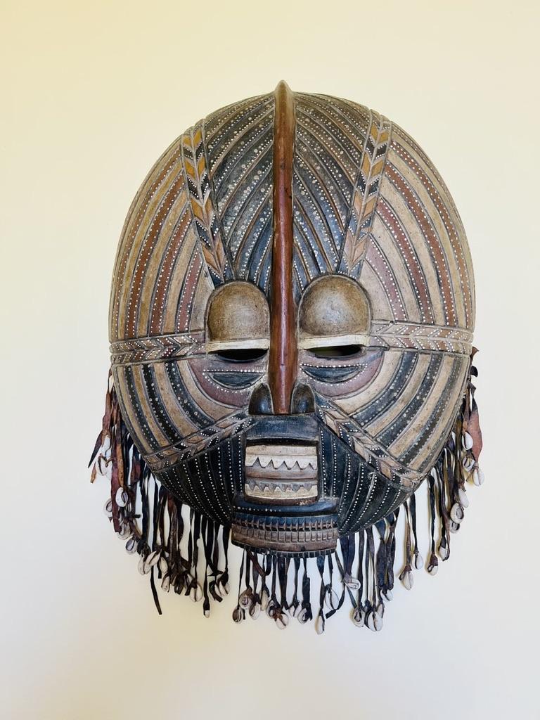 old and big african mask in wood, leader and whelks 