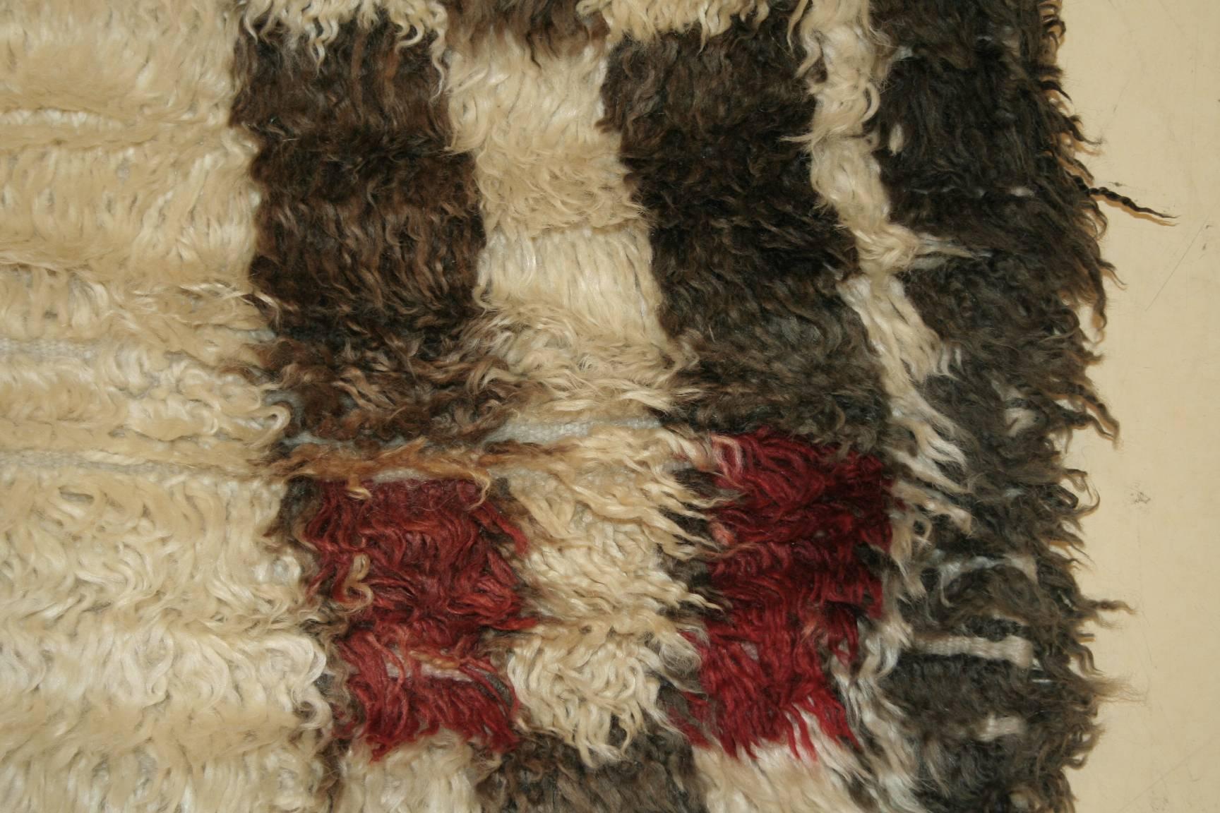 The Beni Ouarain confederation is composed of seventeen tribes inhabiting the high mountain region of the northeastern Middle Atlas. Their rugs differ from other Berber weavings in that they are woven almost exclusively on an ivory background and