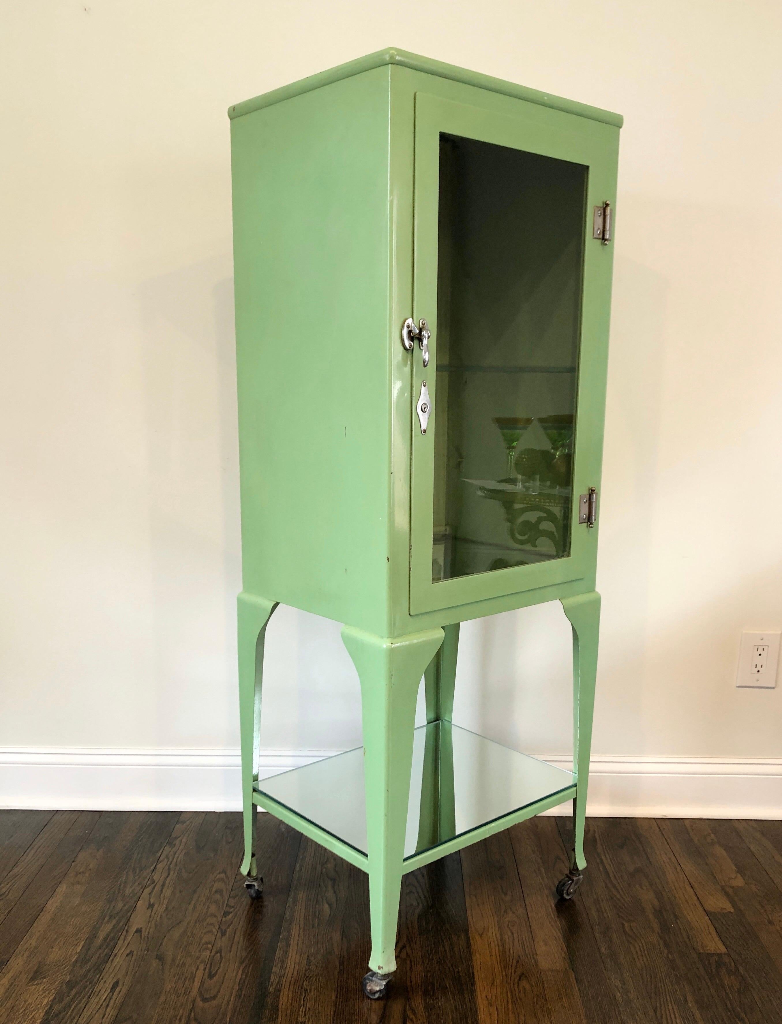 Nice old antique cabinet in unusual citrus green paint. Chrome-plated hardware. Mirrored glass bottom shelves. Minor chips to paint. Measures: 56 1/2
