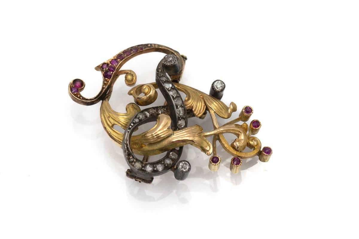 Broche en vieil or (avec des éléments en argent) avec diamants et rubis

23 diamants pesant environ 0,65 ct et 15 rubis pesant 0,35 ct sertis sur un moule Art Nouveau

or jaune pr. 0.750 (18K) et argent sterling 0.950

origine : Espagne, début du