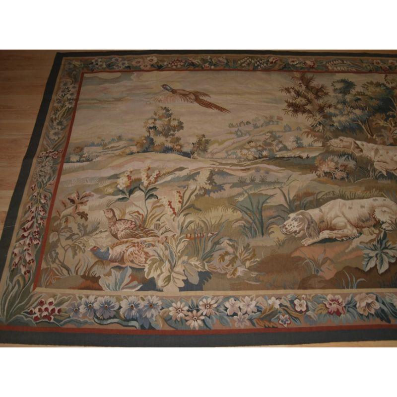 A good Aubusson in the style of a 19th century English tapestry.

About 10 years old.

This beautiful Aubusson is in the style of traditional English 19th century tapestry with a scene of two spaniel dogs flushing out a brace of pheasants.

The