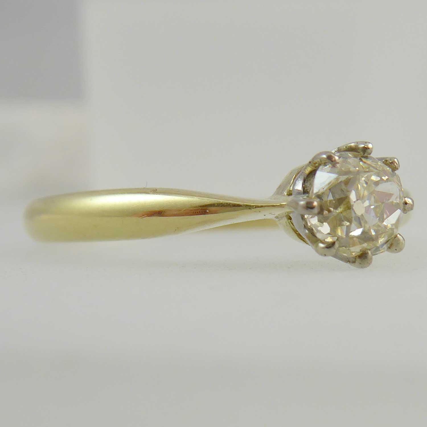 A delightful vintage solitaire ring perfect for the petite hand.  Set with an old brilliant cut diamond in a white claw setting and with a known weight of 0.65ct.  Clarity is assessed as VS and colour tinted.  Plain polished yellow band stamped 18ct