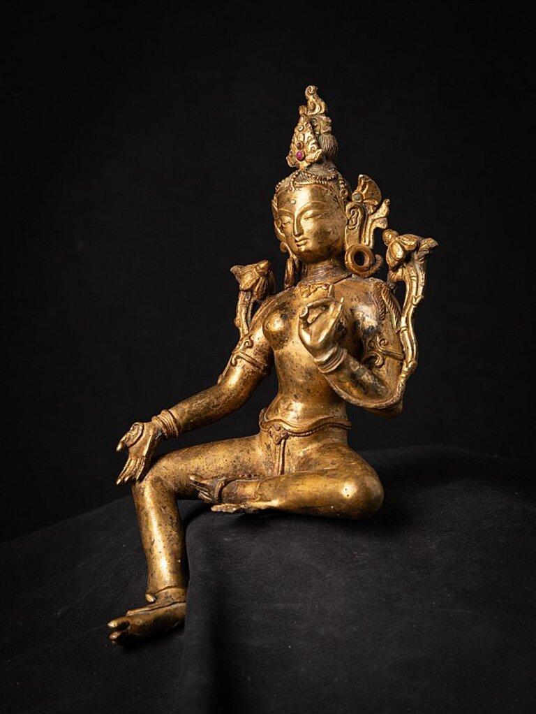 Material: bronze
Measures: 27,5 cm high 
14,4 cm wide and 11.6 cm deep
Weight: 1.263 kgs
Fire gilded with 24 krt. gold
Vitarka mudra
Originating from Nepal
Middle 20th century
With inlayed gem stones.
  
