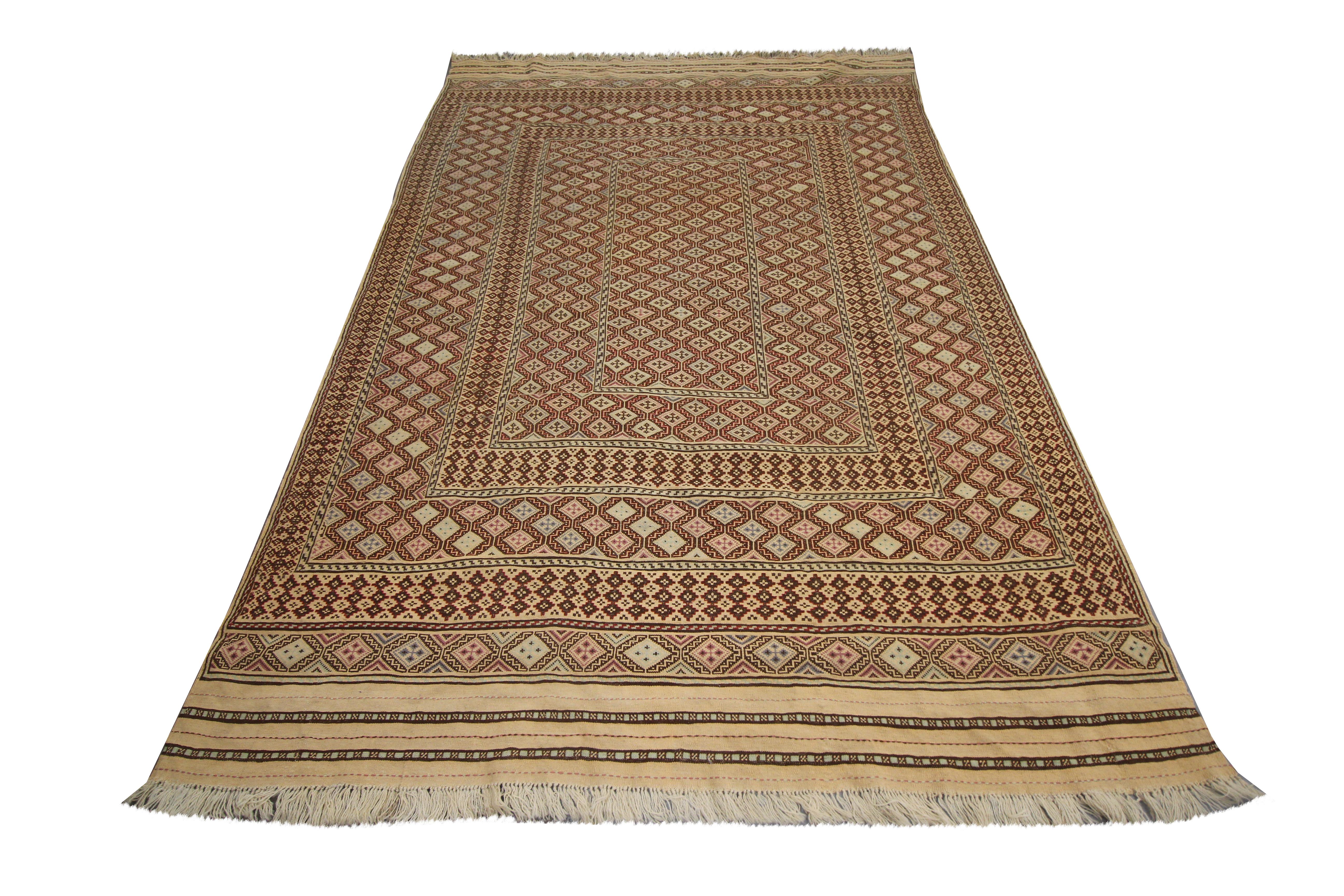 This old wool area rug is a handwoven Afghan Soumach kilim woven by hand in the 1930s. The design is intricate featuring a bold geometric design, symmetrically woven with diamond tribal motifs. The colour palette is rustic with a beige background