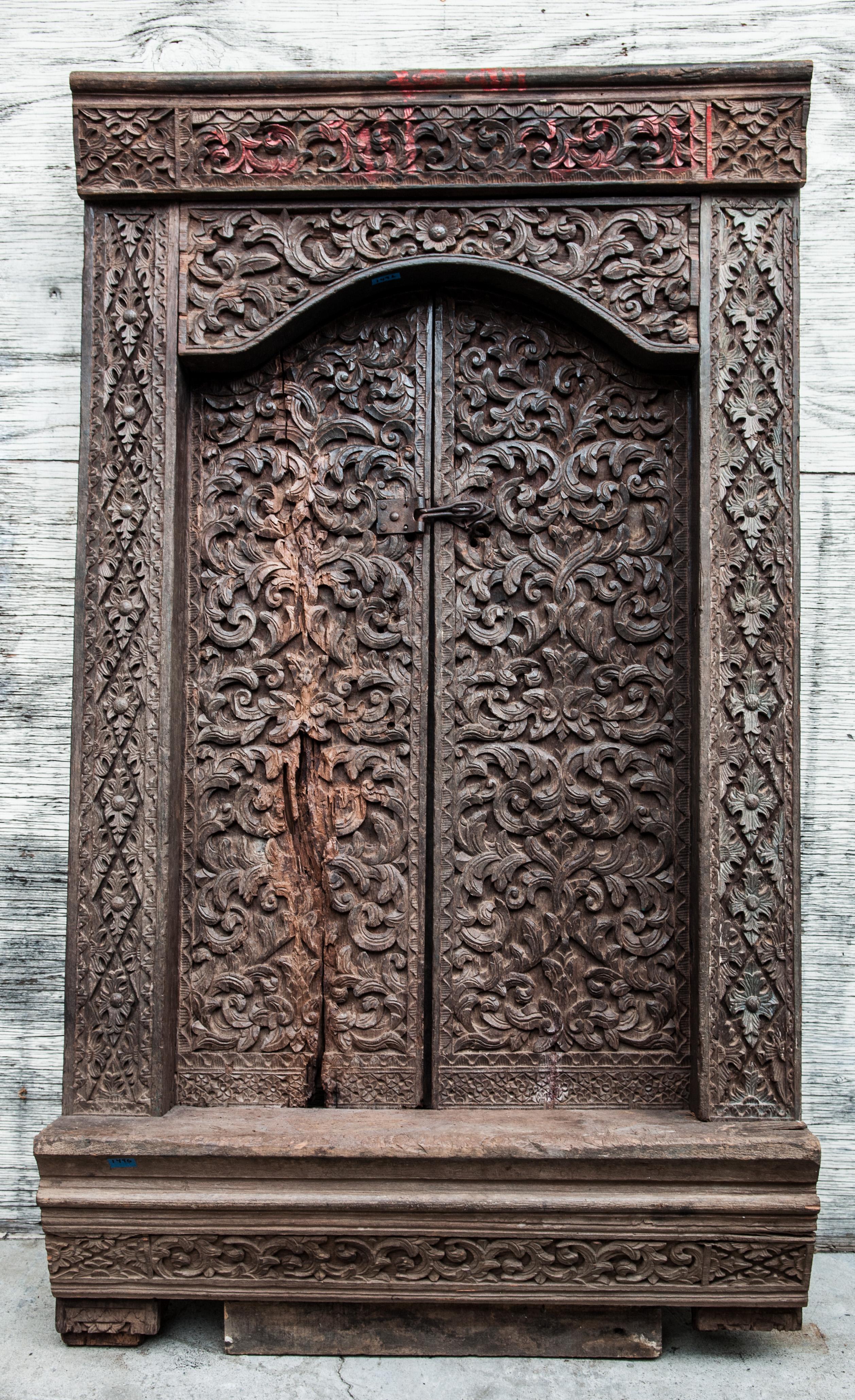 Old carved door and frame from Sumatra. Merbau wood. Early to mid-20th century. 
This rare and wonderfully rendered door from Sumatra, most likely from the area of Lampung, or perhaps Minangkabau, is carved from merbau wood, an extremely dense