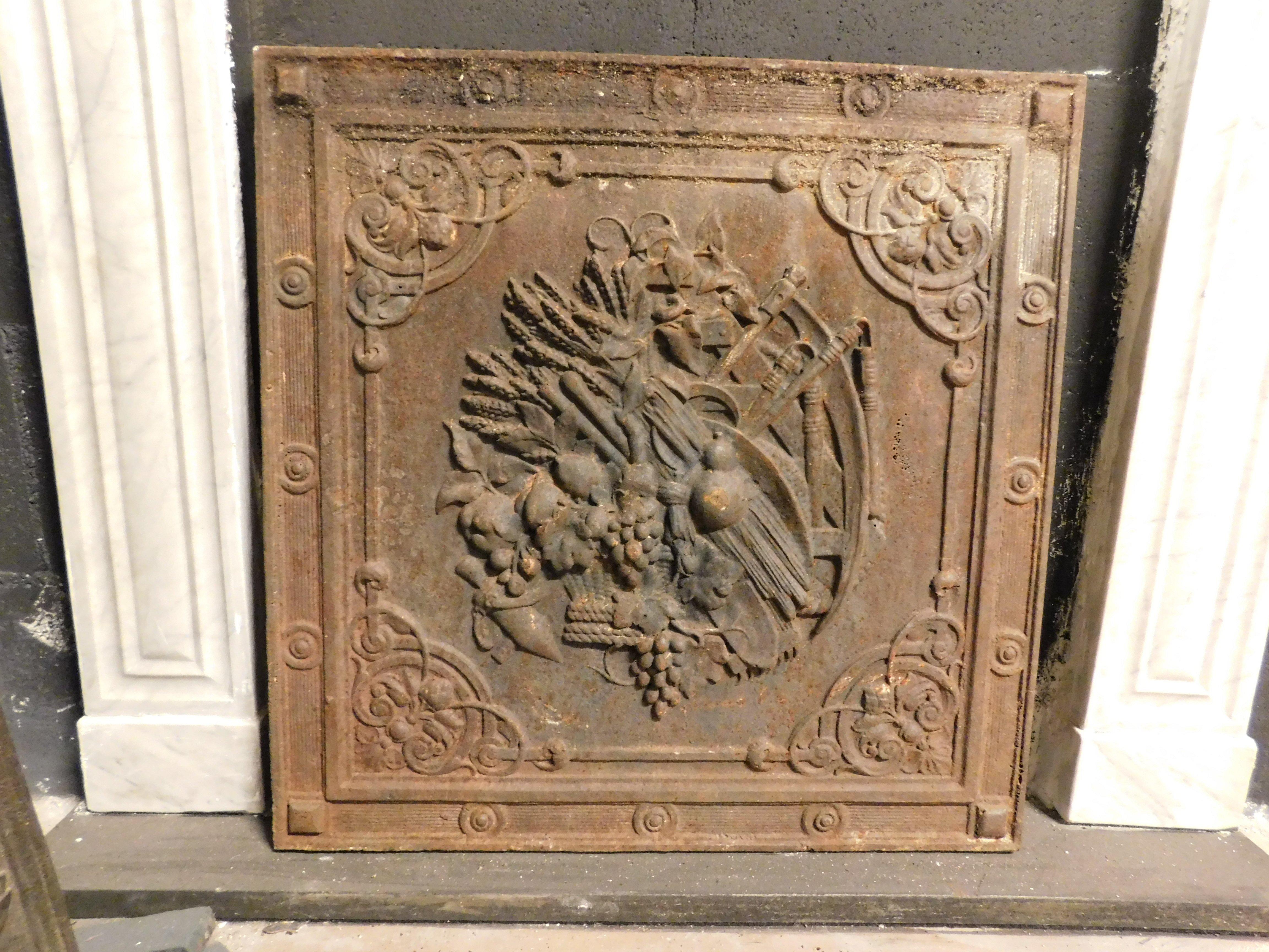 Plaque de cheminée ancienne en fonte, richement sculptée d'outils et de produits agricoles, 19e siècle, L 57 x H 58 cm.