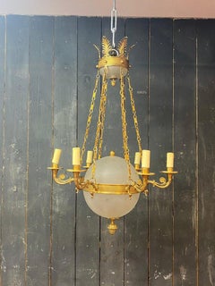 Old chandelier in bronze and frosted glass decorated with engraved stars.