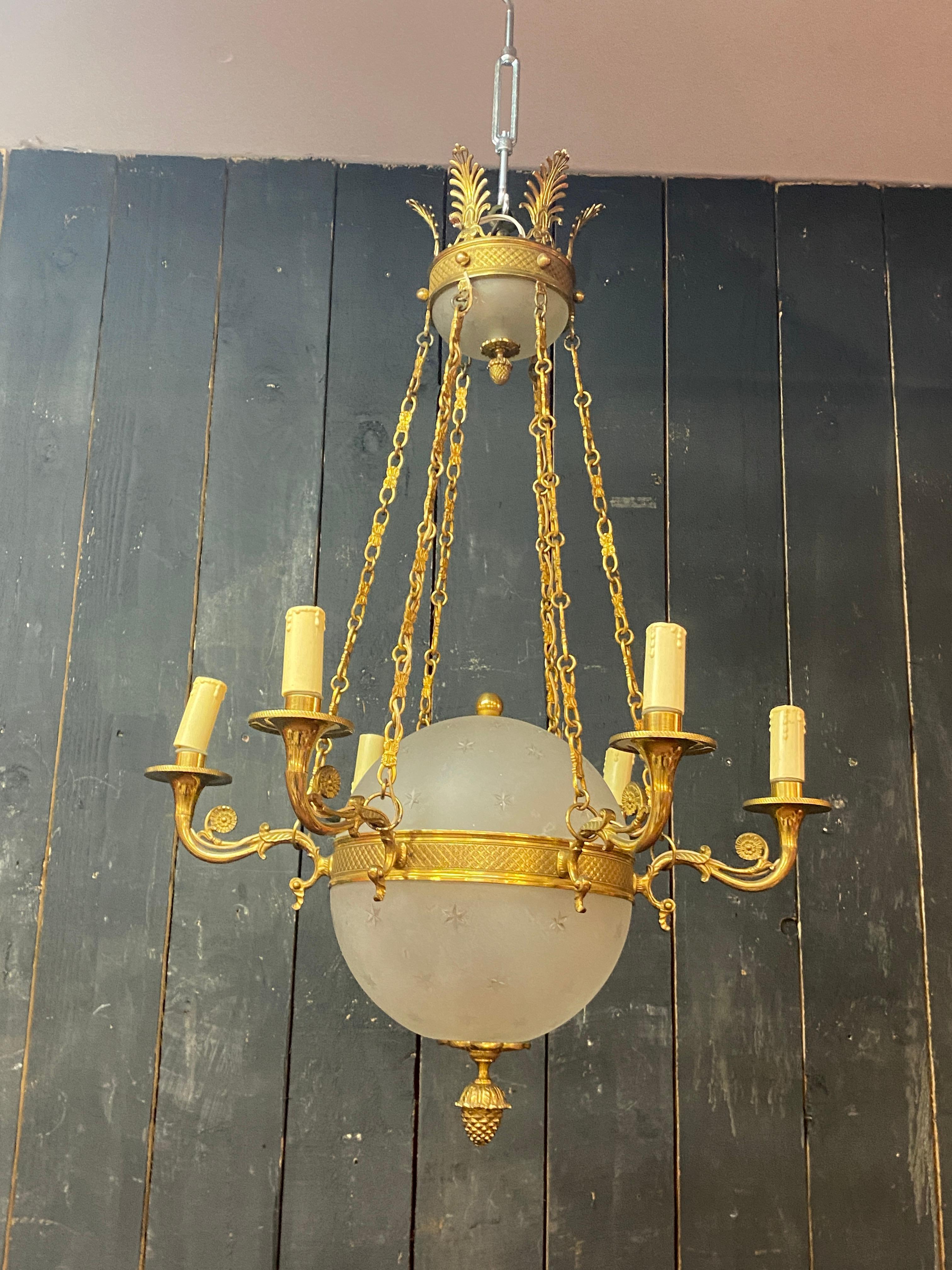 Neoclassical old chandelier in bronze and frosted glass decorated with engraved stars.  For Sale