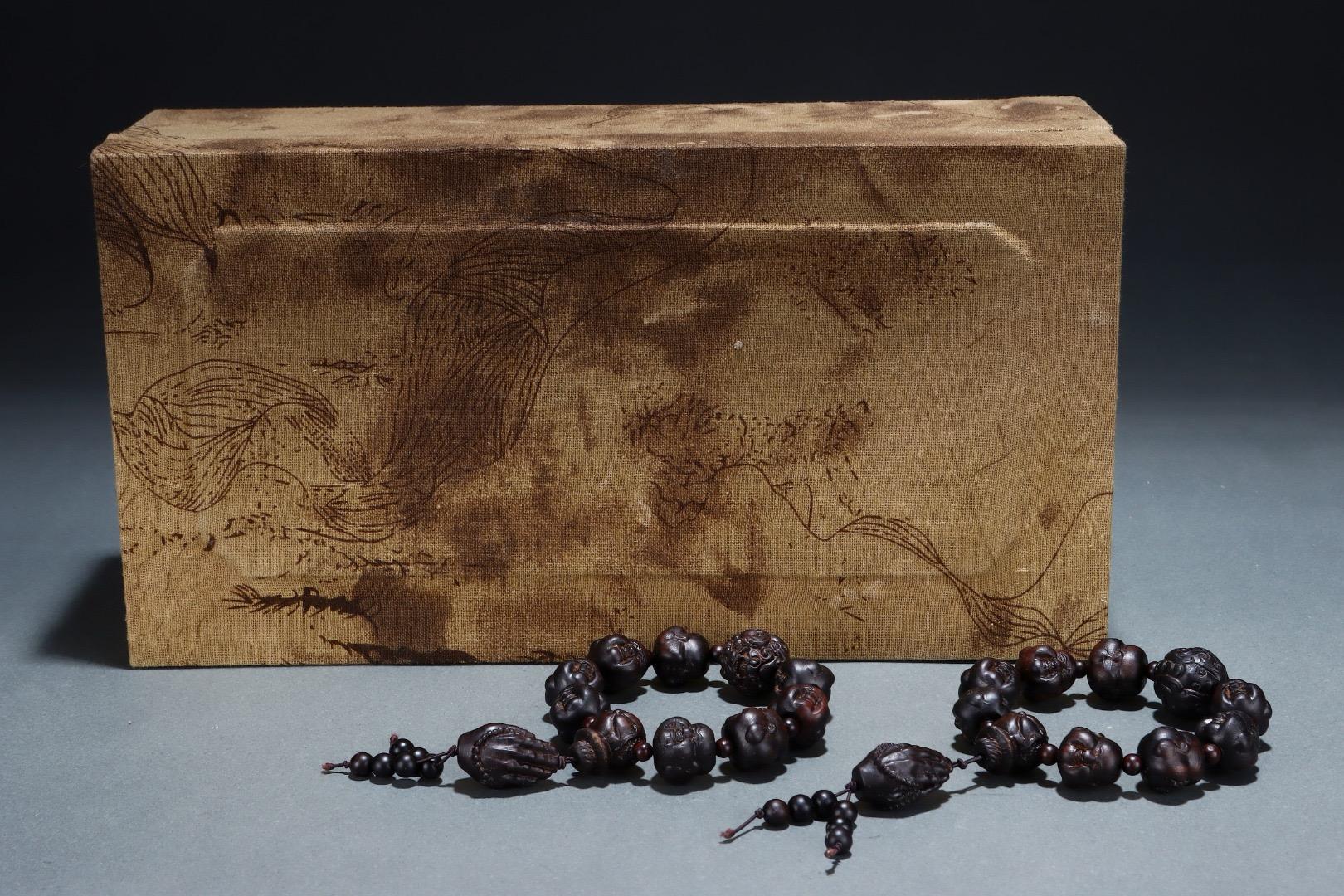 Este par de pulseras de cuentas de discípulo de Buda talladas en madera de agar de la antigua China es un conjunto sagrado e intrincadamente elaborado que simboliza la devoción, la sabiduría y la protección espiritual. Cada pulsera está hecha a mano