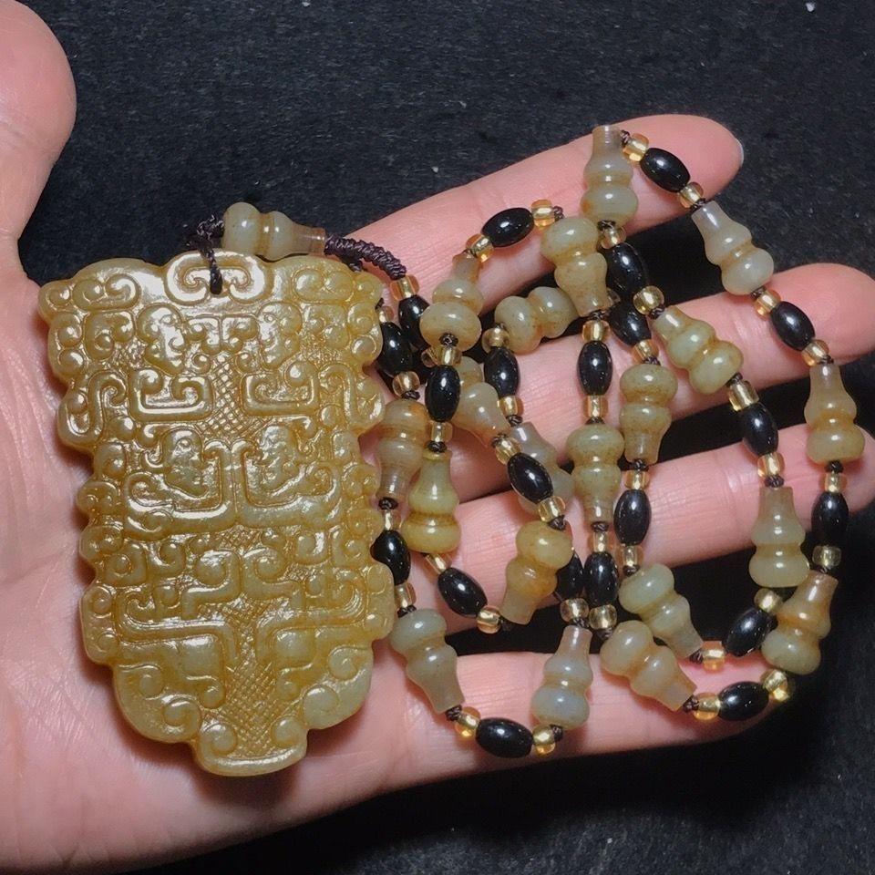 Ce pendentif en jade Hetian chinois d'époque est orné d'un masque de bête à deux faces, symbole traditionnel chinois de protection, de force et de pouvoir. Sculpté à la main dans du jade Hetian de première qualité, réputé pour sa texture lisse, son