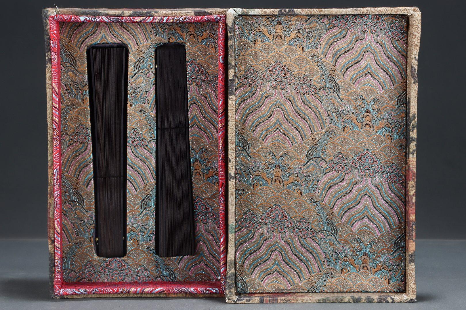 Cette paire d'éventails impériaux chinois en bois d'agar est un magnifique exemple d'artisanat royal et d'élégance culturelle. Elle est fabriquée à la main à partir de bois d'agar précieux, un matériau très prisé dans la Chine impériale pour sa