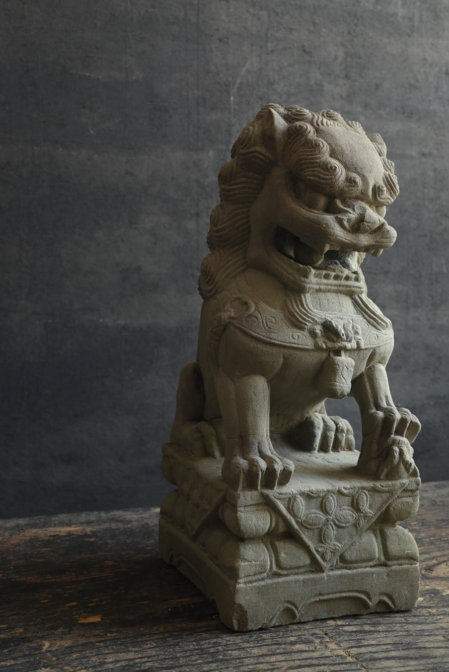 This is a stone lion statue made in China, presumably in the 20th century or later, during the Republic of China period. The material used is sandstone, which has a fine and rough texture, and the natural erosion of the stone over time has given it