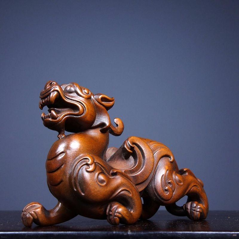 This Old Chinese Wood Carving Statue features a powerful Pixiu, the legendary creature revered in feng shui for attracting wealth, protection, and good fortune. Expertly carved from fine wood, the statue captures the mythical strength and fierce