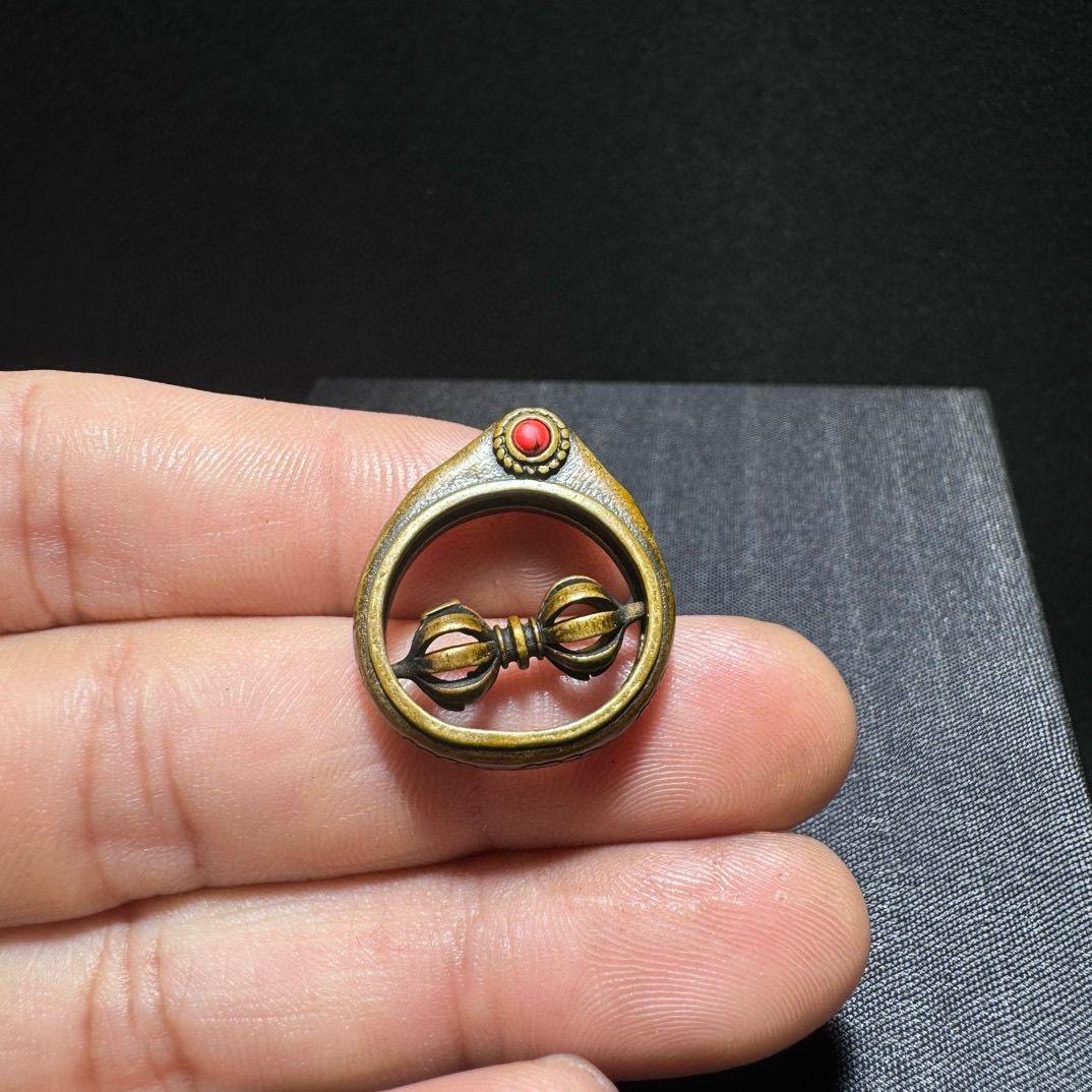 This Old Tibetan Bronze Turning Vajra Pestle Ring is a powerful symbol of spiritual strength, protection, and enlightenment. Skillfully crafted from solid bronze, the ring features a rotating vajra (dorje) design, representing the indestructible