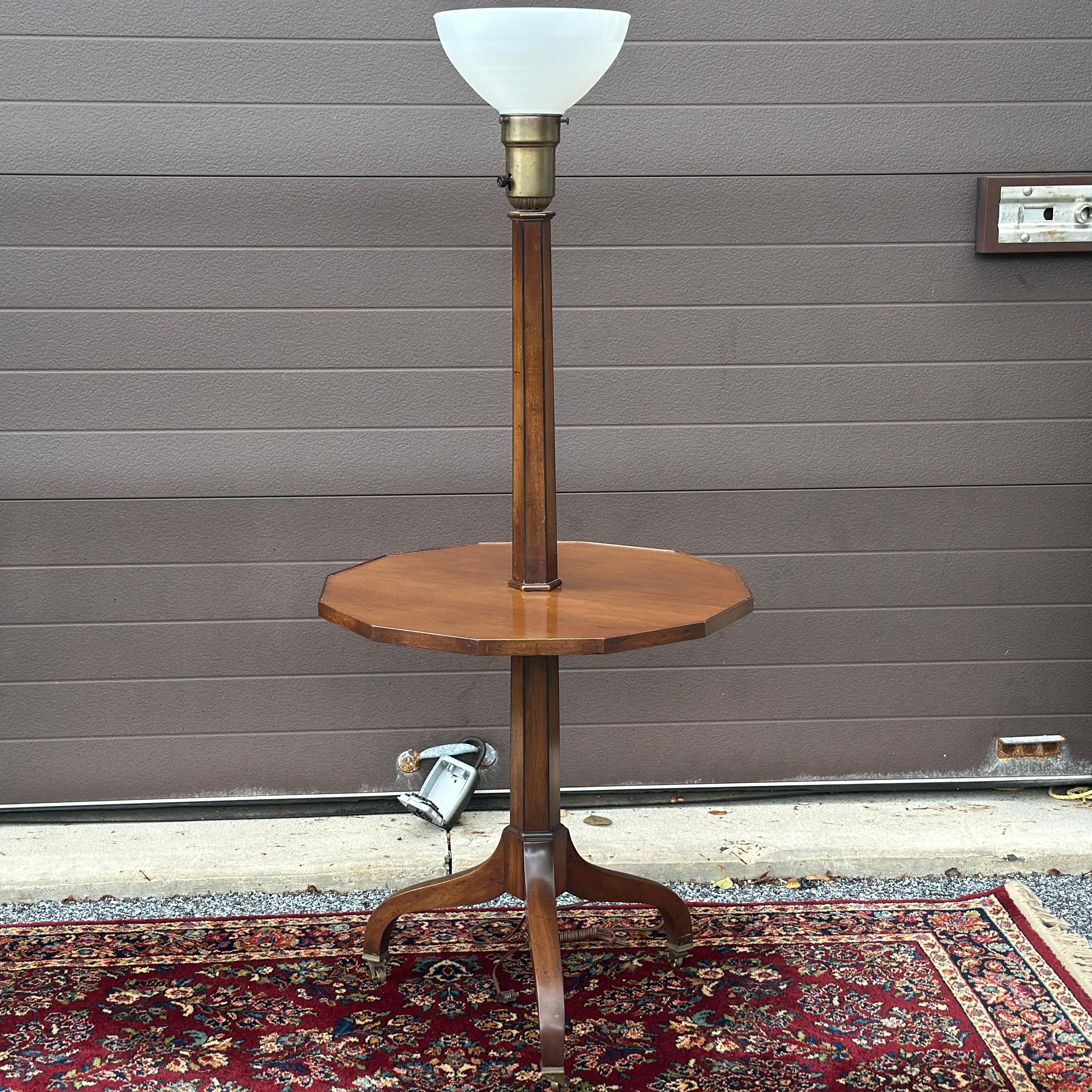 Top quality floor lamp table by Old Colony Furniture Co. on curved leg tripod base with brass casters. Tagged on underside of table.