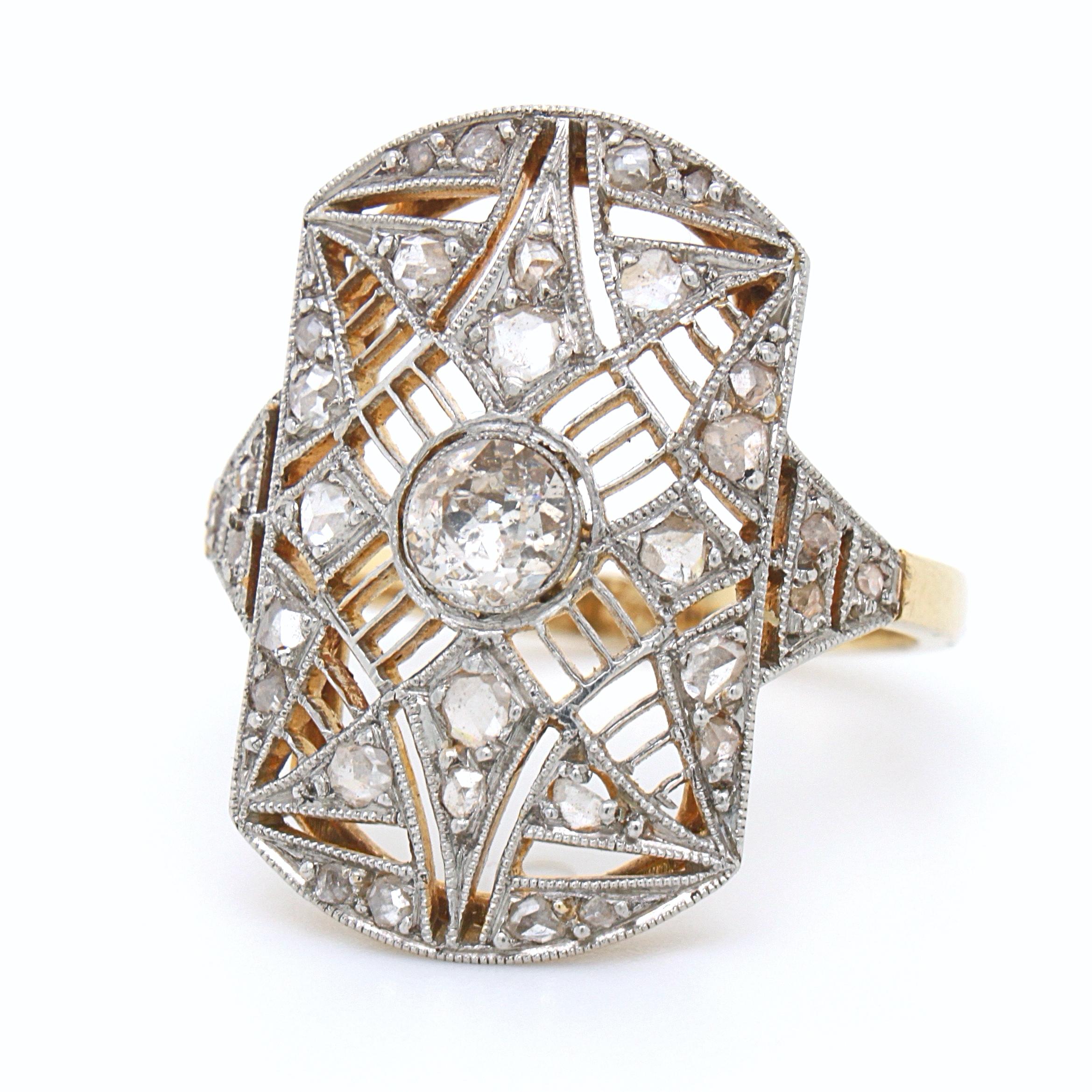 An old European cut and rose cut diamond ring in yellow gold and platinum, ca. 1890s. 

The ring is beautifully designed as a star emblem in a filigree milgrain platinum setting. The backside of the ring is in yellow gold. The ring is marked AS and