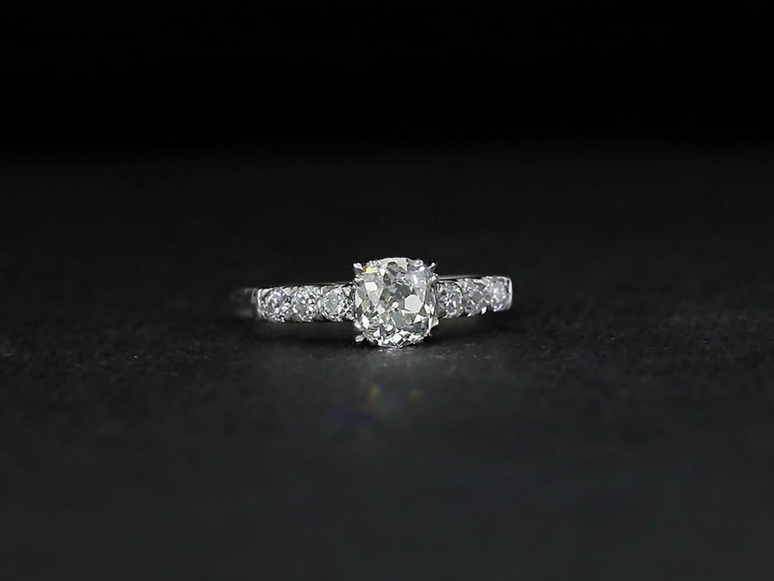 This classic engagement ring is centered with a cushion diamond set in a vintage platinum claw setting. Six old mine diamonds accent the ring's shank for added brilliance. 

DIAMOND DETAILS
 - Center Stone: Old cushion cut diamond with approximate