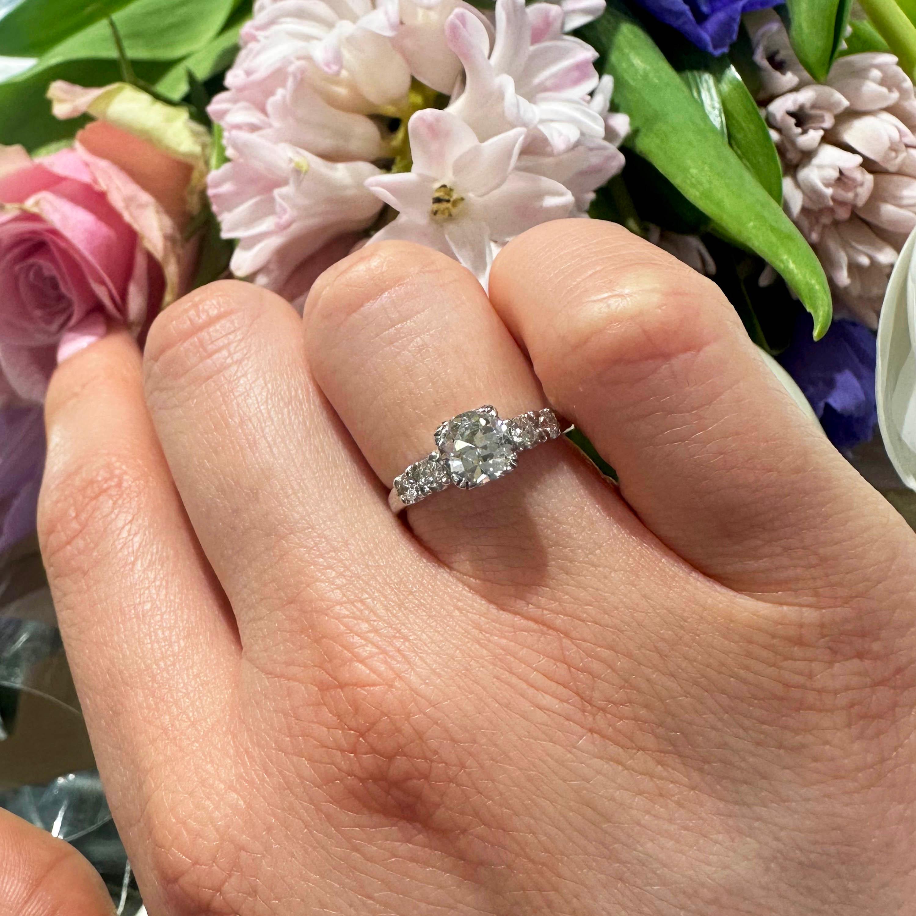 A vintage diamond ring set with an old-cut diamond weighing 0.75 carats, of E colour and VS1 clarity, with two round brilliant-cut diamonds set in each shoulder, mounted in platinum. Accompanied by an EGL diamond certificate.

Finger size UK I ½ /
