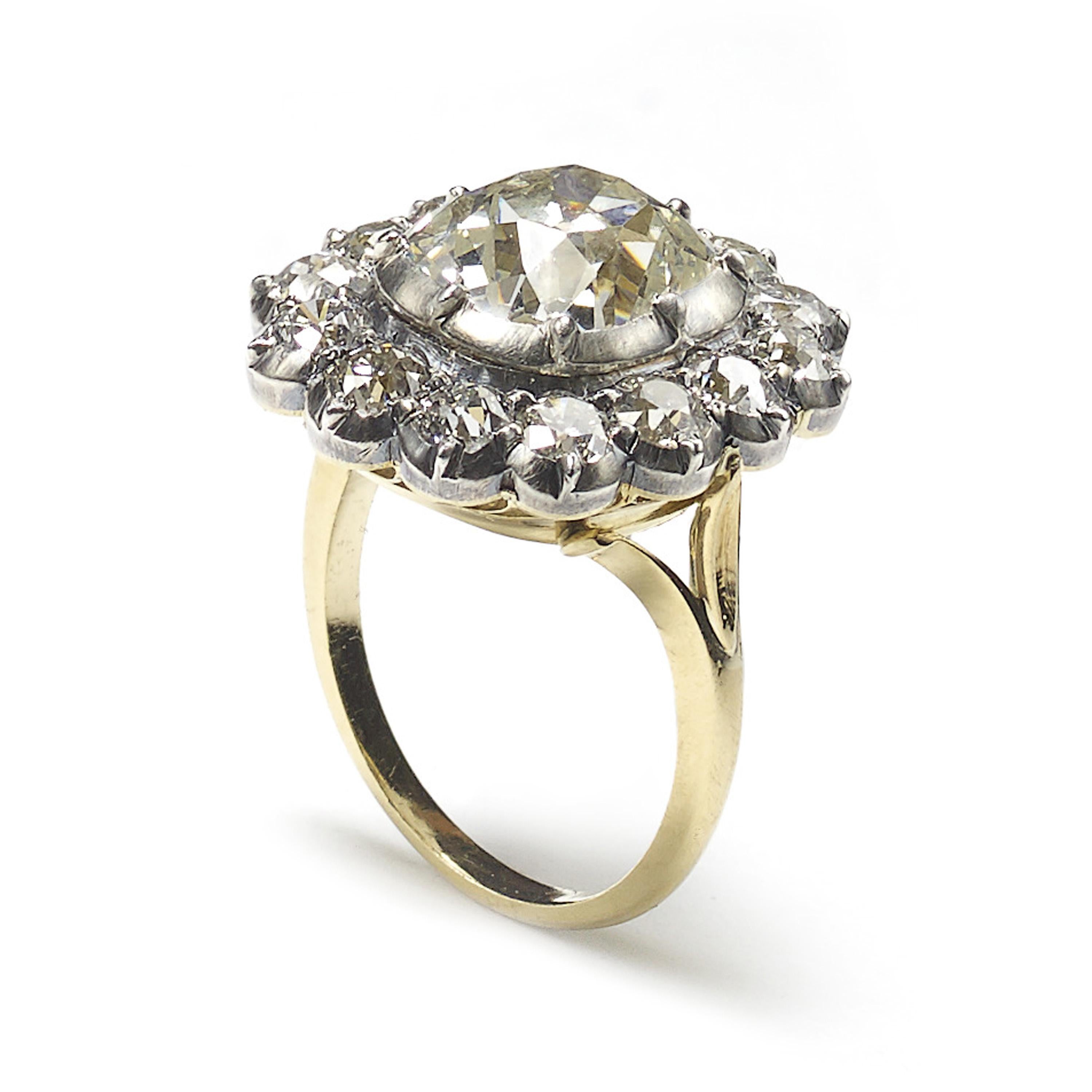 A diamond cluster ring, set with a 4.18ct, J colour, VS2 clarity, cushion shaped, old-cut diamond, surrounded by fourteen, old-cut diamonds, with an approximate total weight of 2.26ct, in cut down settings, mounted in silver-upon-gold, accompanied
