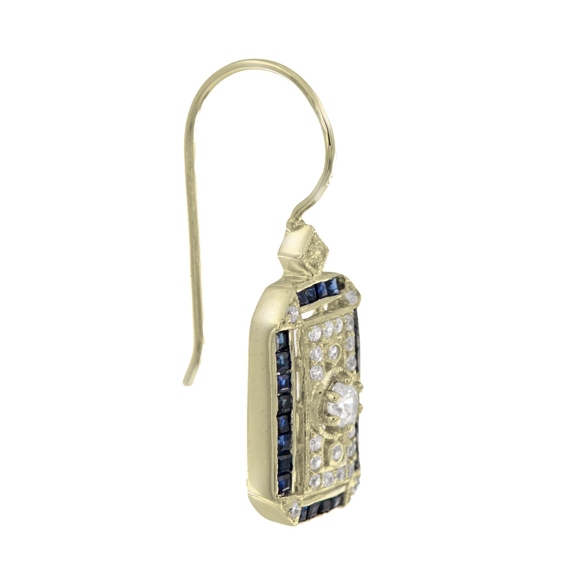 Stunning Antique inspired diamond and sapphire drop earrings. Bezel set in the center is an old cut diamond of approx. 0.11 carat each side. The outer columns are adorned with a beaded design. Framing the entire design are narrow French cut baguette