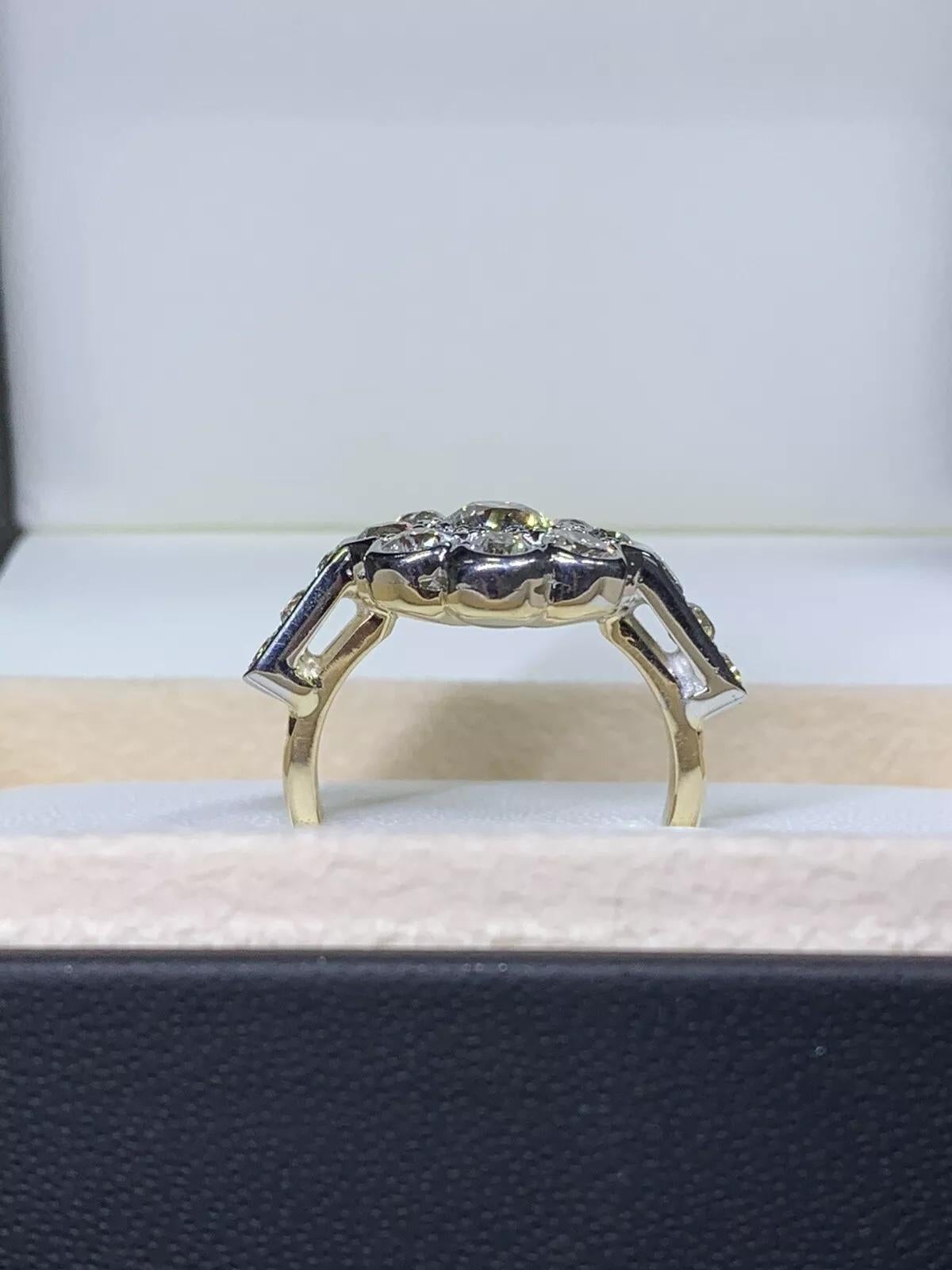 Scopri l'eleganza senza tempo del nostro anello di fidanzamento con cluster di diamanti taglio antico da 3,32 carati. Realizzato in oro giallo 9ct e argento, questo squisito pezzo ha un peso totale di 8,9 grammi e garantisce una vestibilità comoda e
